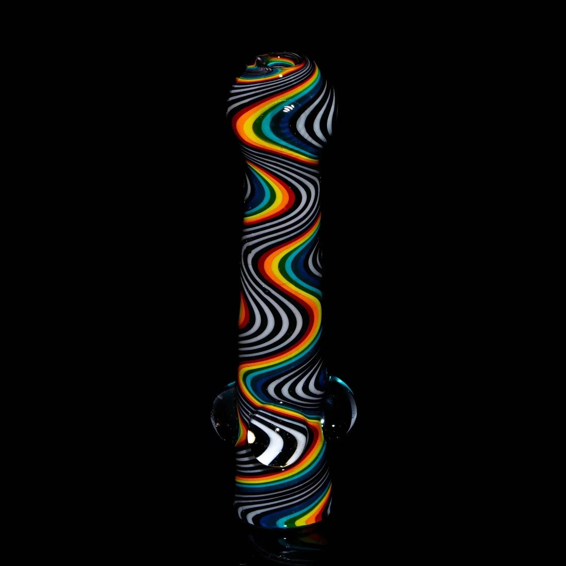 Black glass one hitter pipe with bold rainbow and white wig wag swirl pattern on black background.
