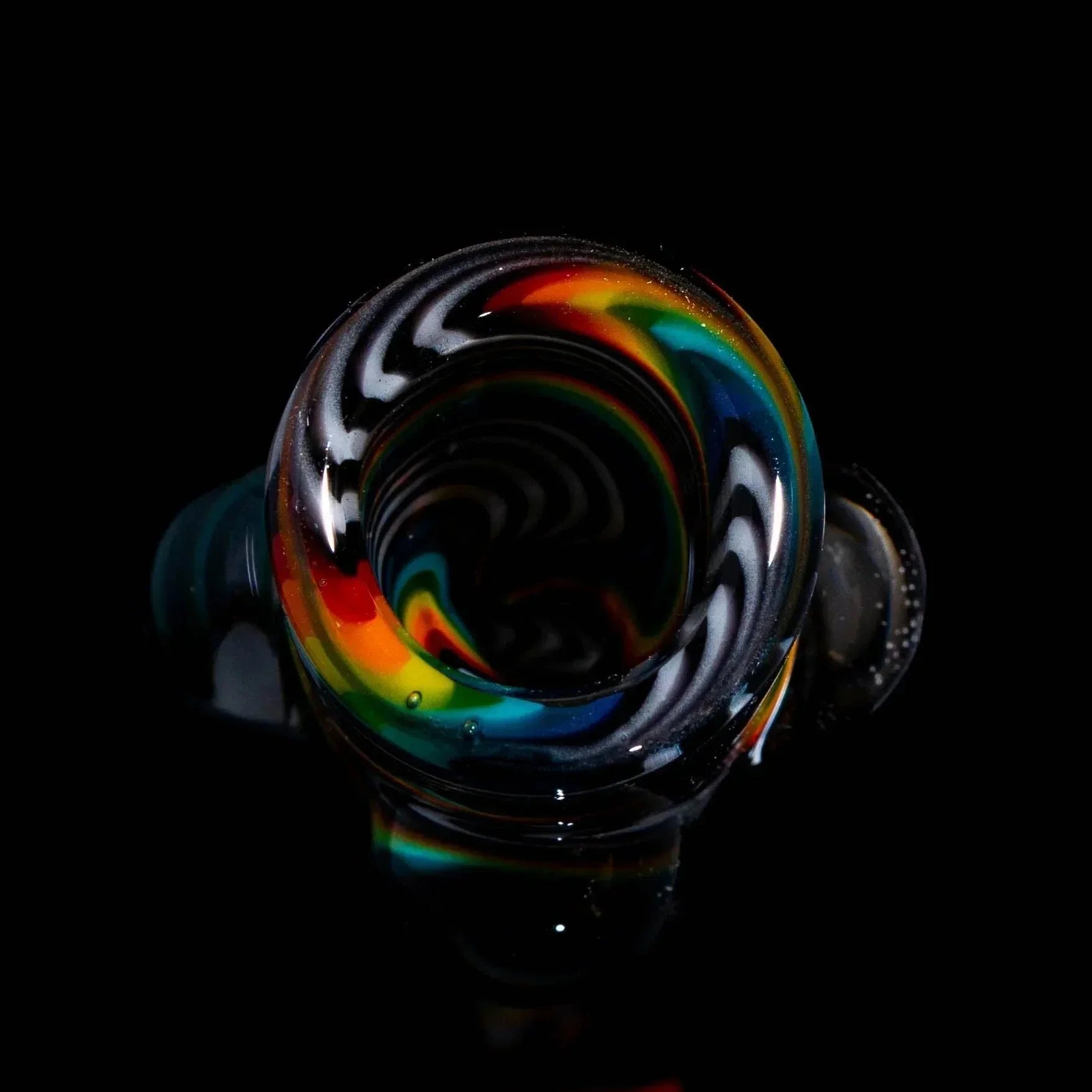 Hand-blown glass chillum with black, white, and rainbow wig wag swirl design on black background