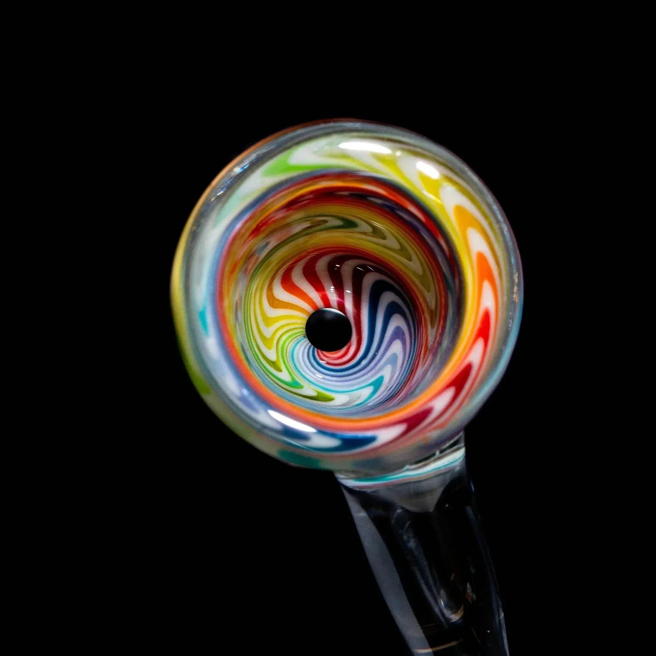 Closeup of a rainbow swirl glass slide bowl with flared edge on black background
