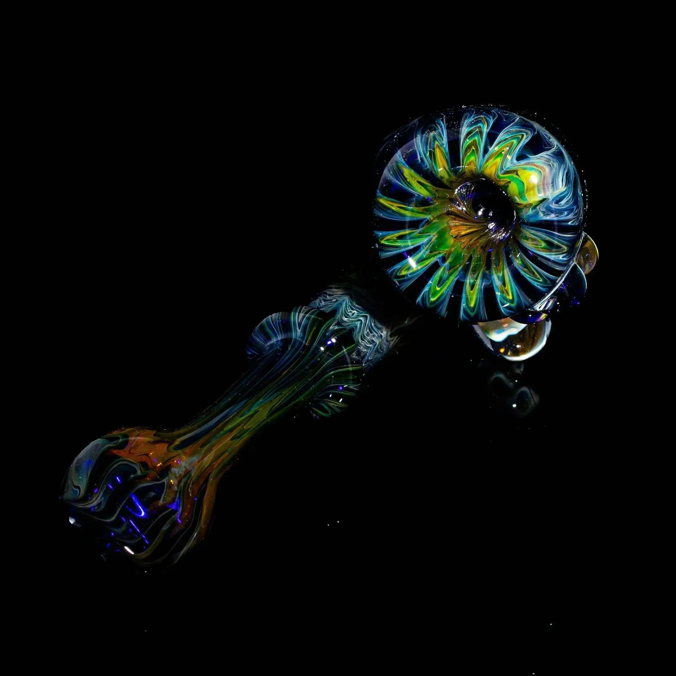 Colorful glass hand pipe with skull design on black background