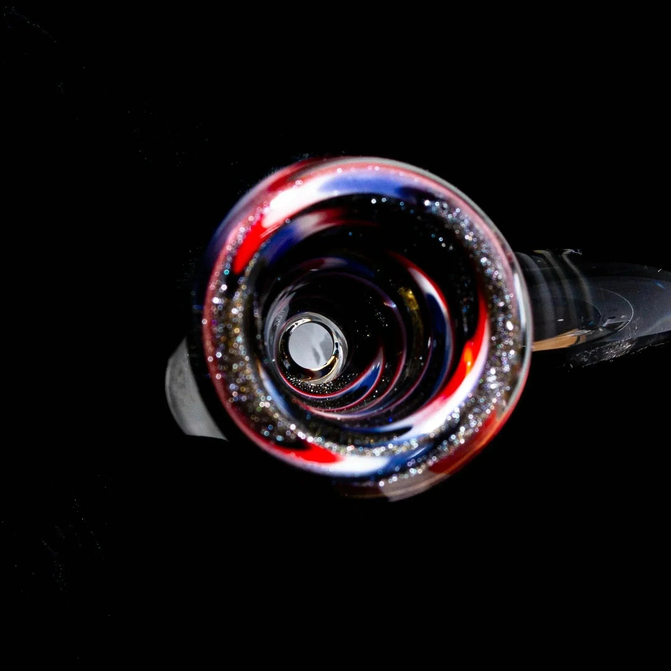 Close-up of a colorful 14mm flare glass slide with wig wag pattern and glitter accents