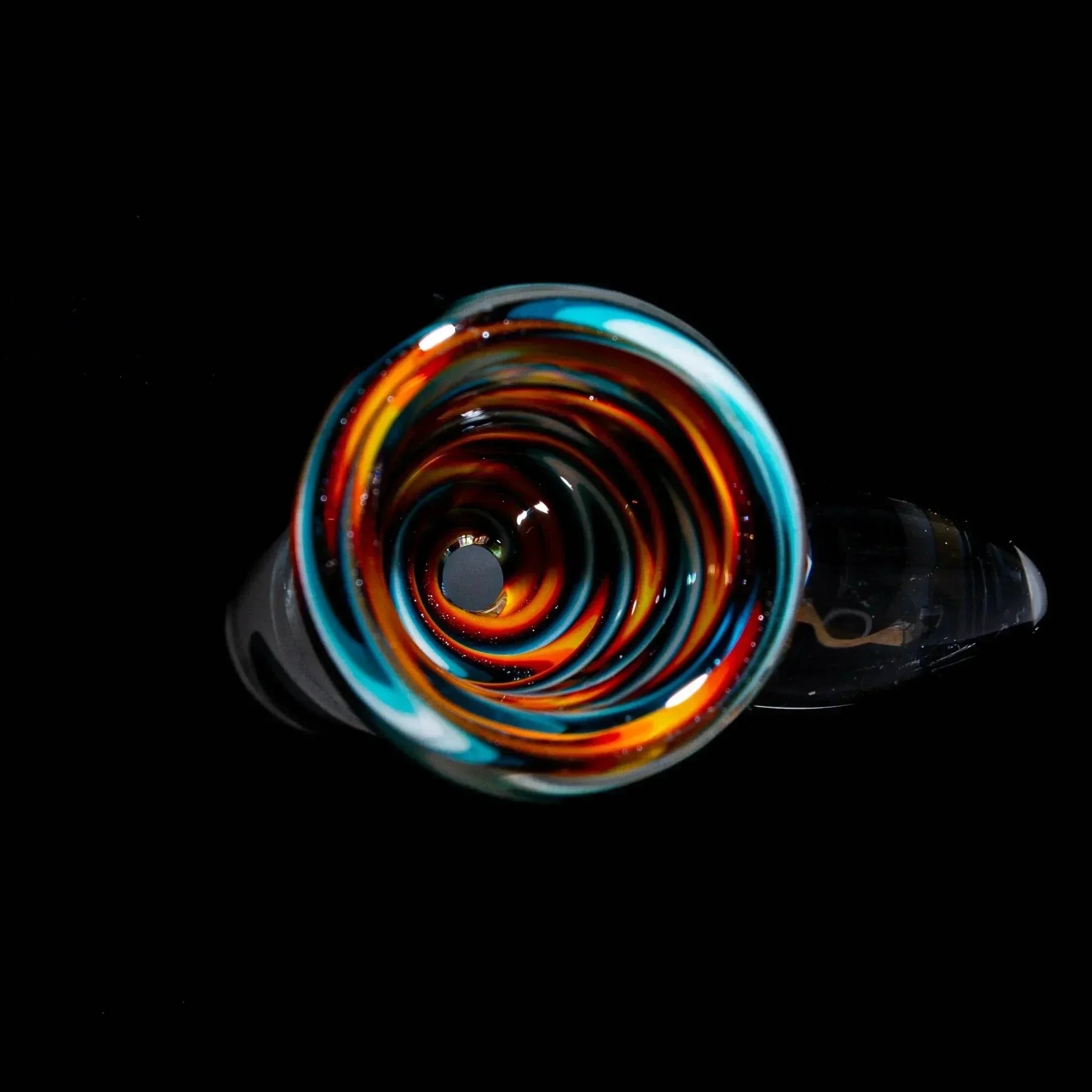 Colorful glass bowl slide with orange, blue, and yellow wig wag swirl pattern on black background