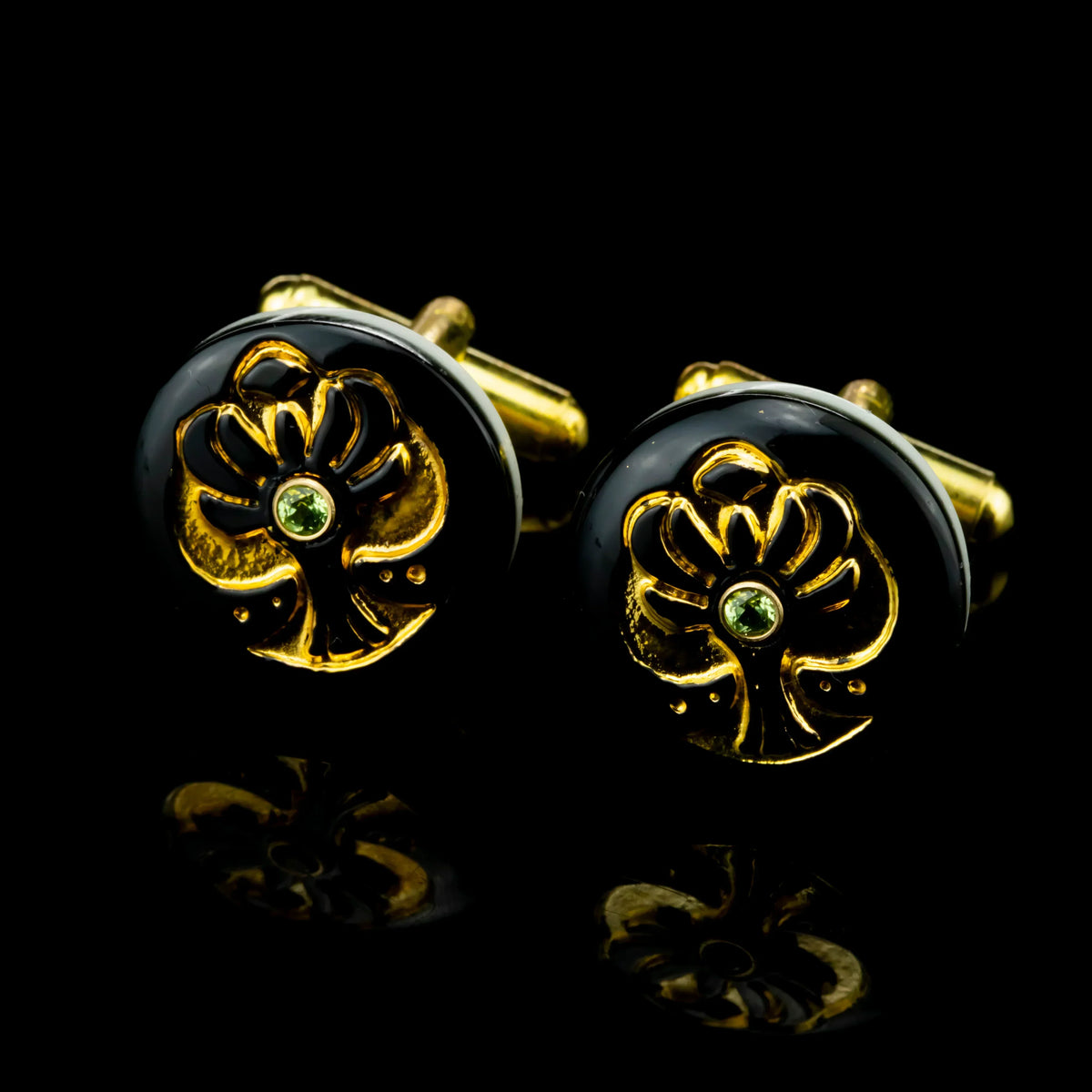 Gold Tree of Life cufflinks with black enamel and green peridot accents on black background