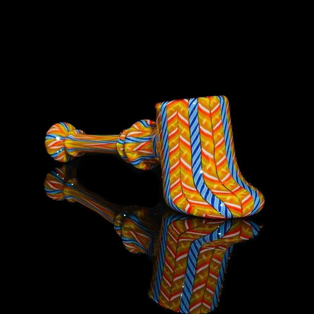 Colorful orange and blue glass hammer pipe with zanfirico cane patterns on black background