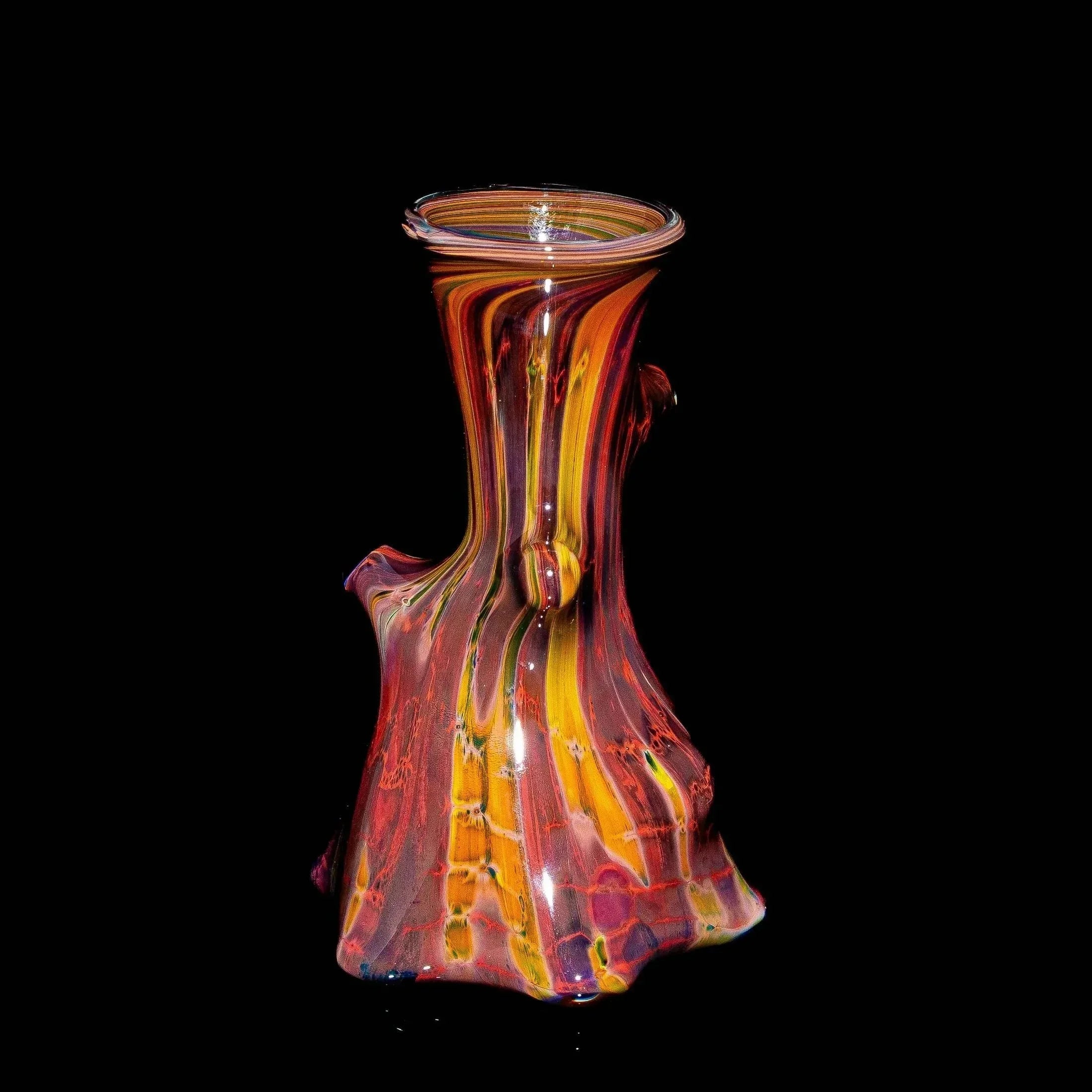 Handcrafted glass vase with marbled orange, yellow, and red colors on a black background
