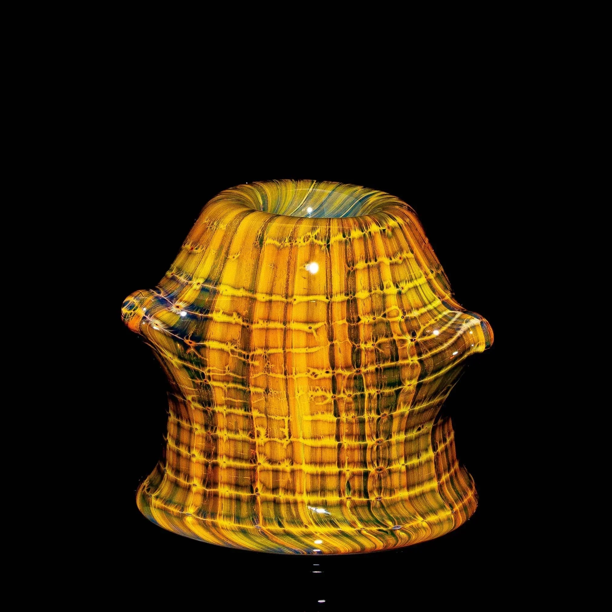 Handblown glass carb cap with yellow and orange striped pattern on black background