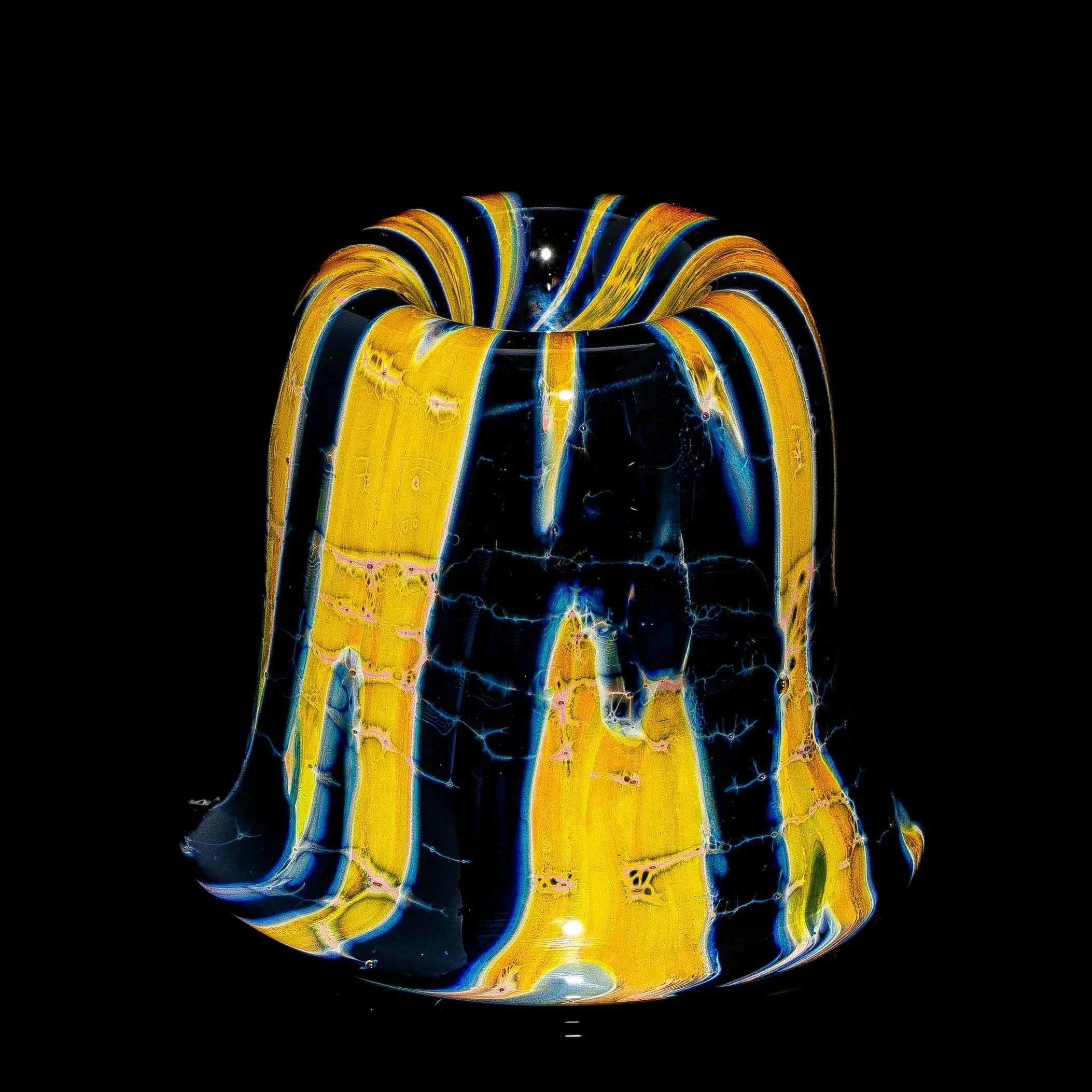Hand-blown glass flare stand with yellow and blue marbled stripes on black background