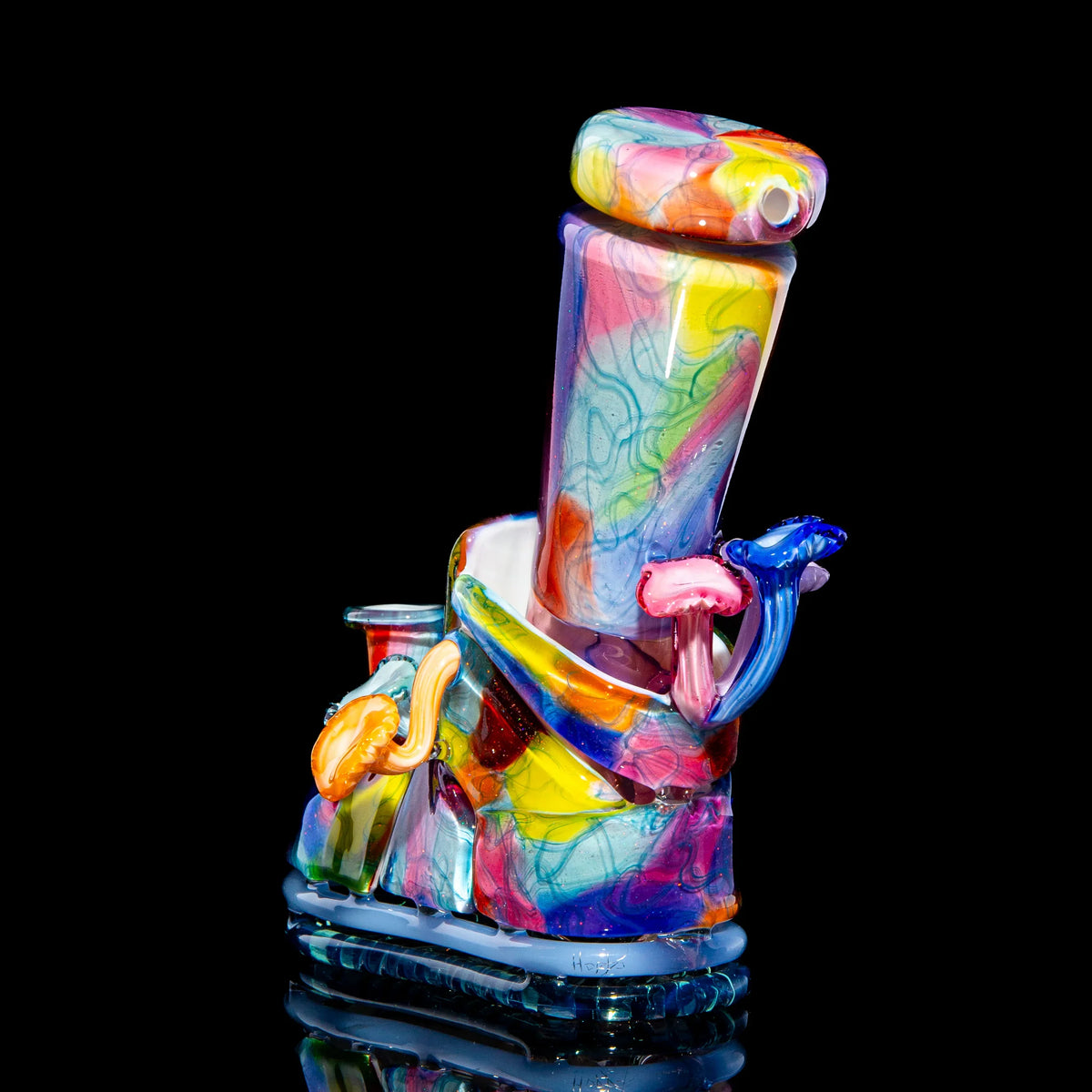Colorful heady glass water pipe with abstract patterns and sculpted accents on black background