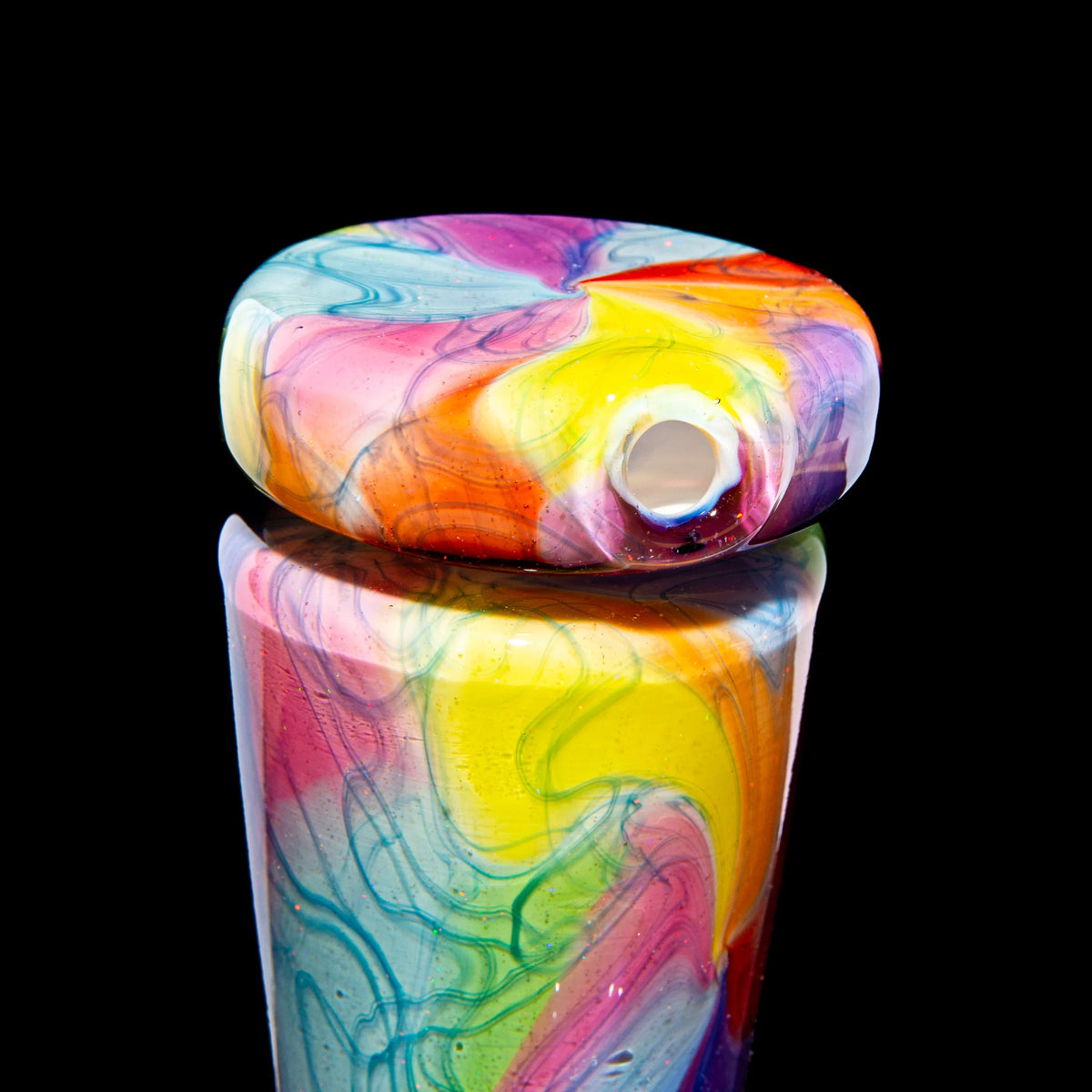 Colorful hand-blown glass carb cap with vibrant swirl patterns on black background