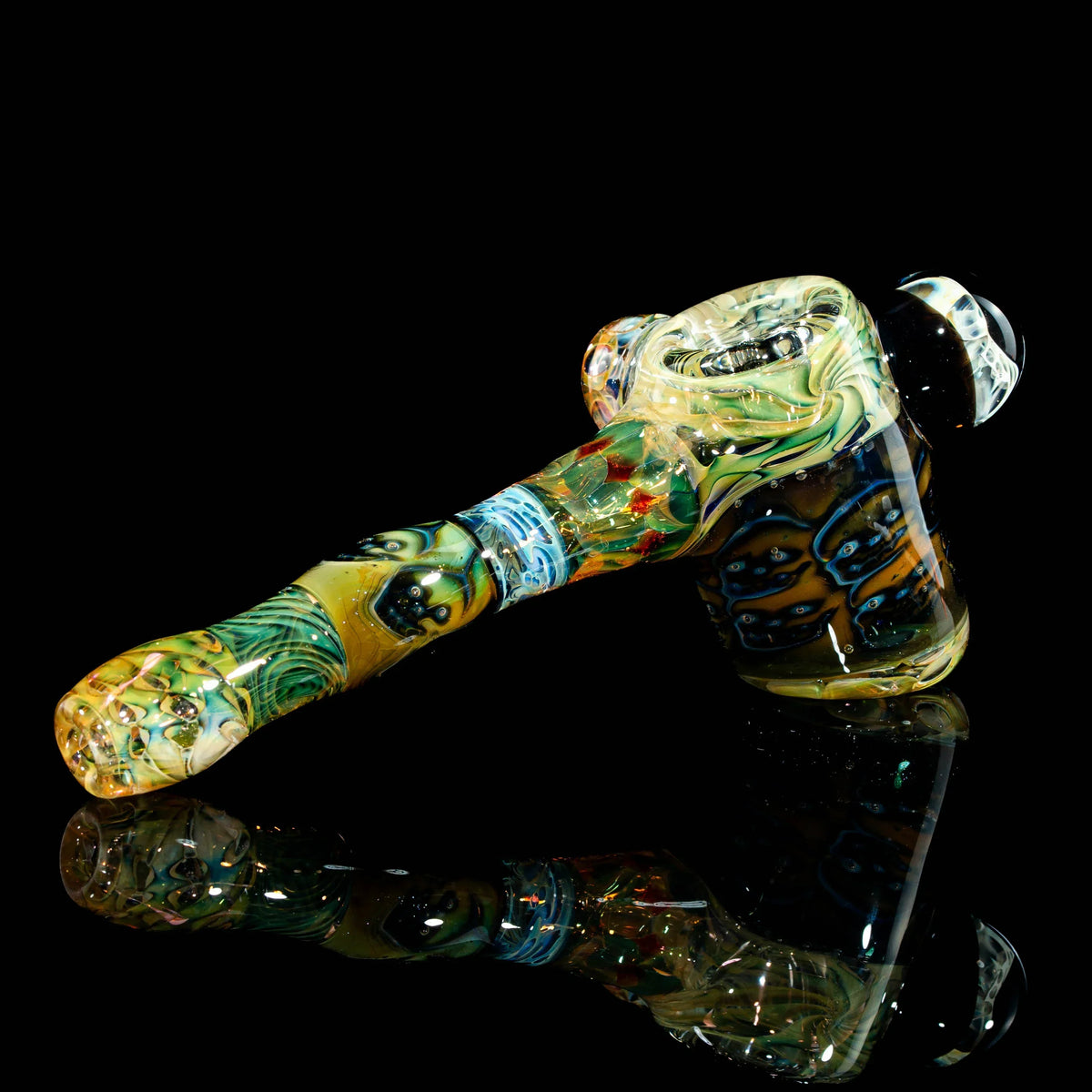 Colorful heady glass hand pipe with intricate designs on black background