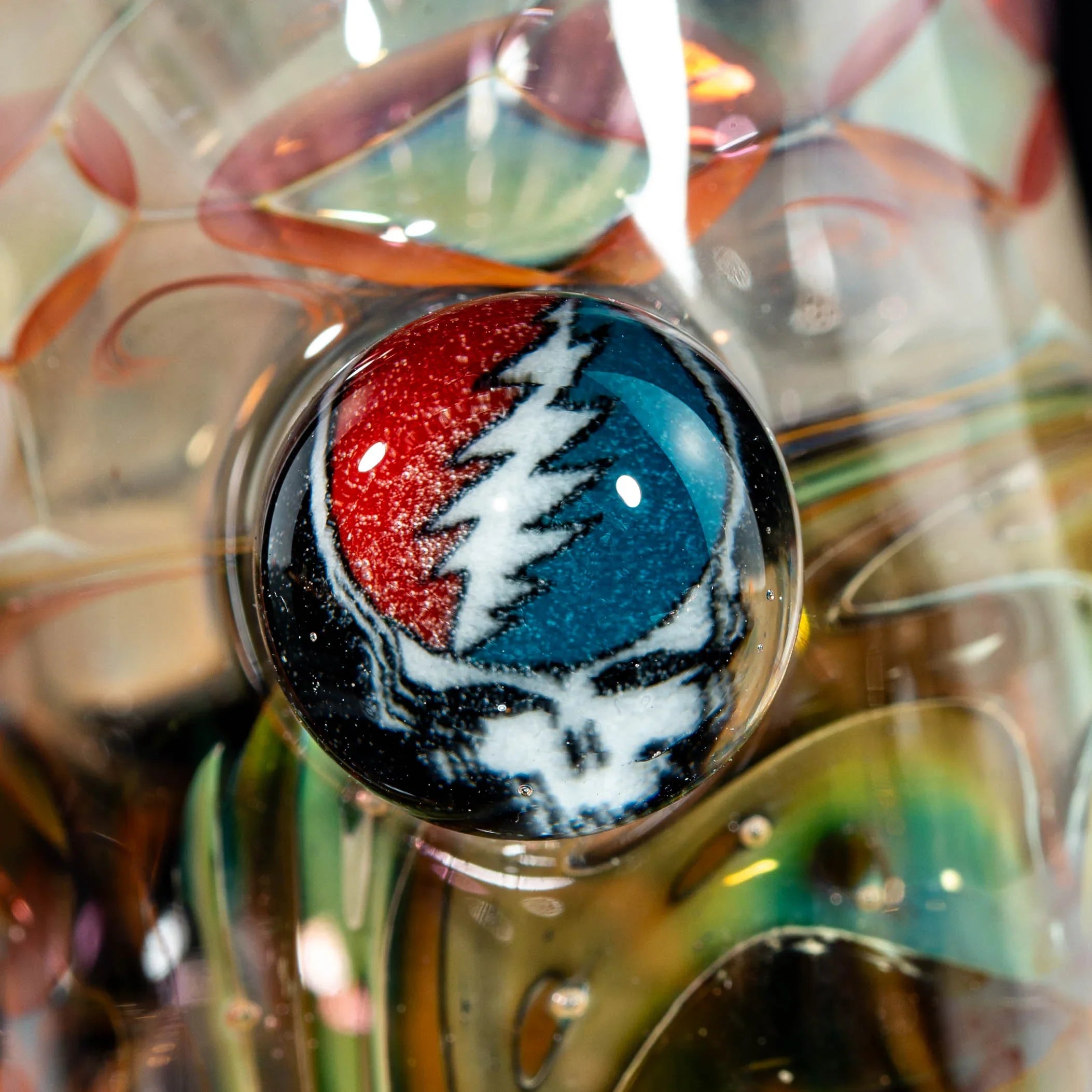 Close-up of heady glass art featuring a colorful skull marble, intricate swirling details