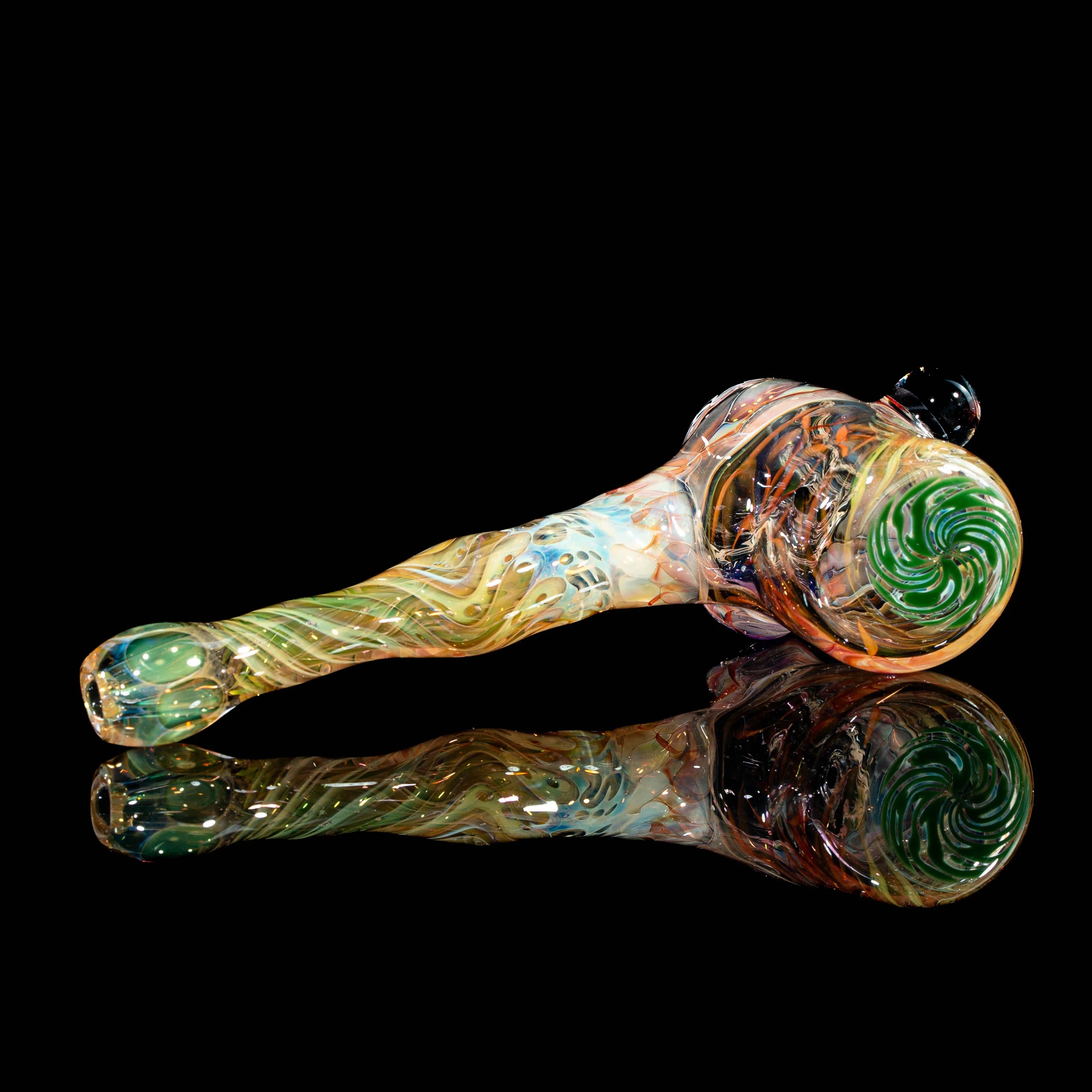 Heady glass hand pipe with swirling multicolor patterns, displayed on a black reflective surface.