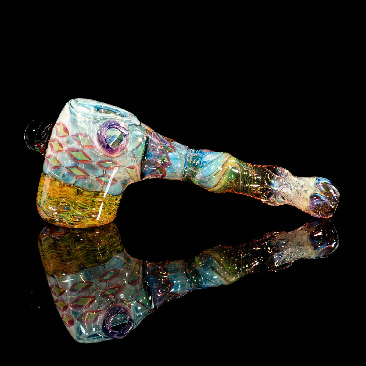 Colorful heady glass hand pipe with intricate patterns and marbles on a black reflective surface.