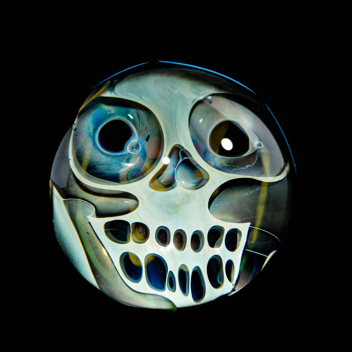 Handcrafted glass marble with skull art, colorful fumed detailing on black background