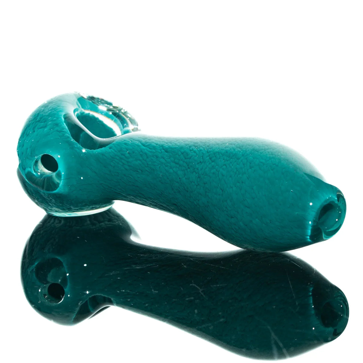 Aqua blue glass spoon pipe with frit texture, displayed on a reflective surface