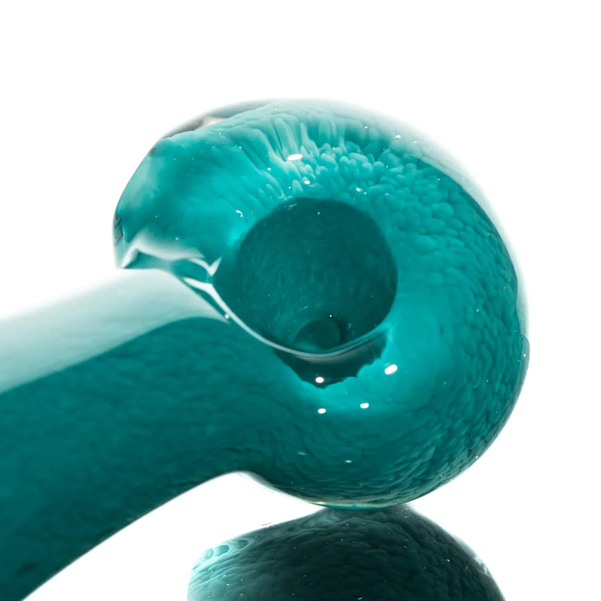 Close-up of aqua blue glass hand pipe with fritted texture on white background