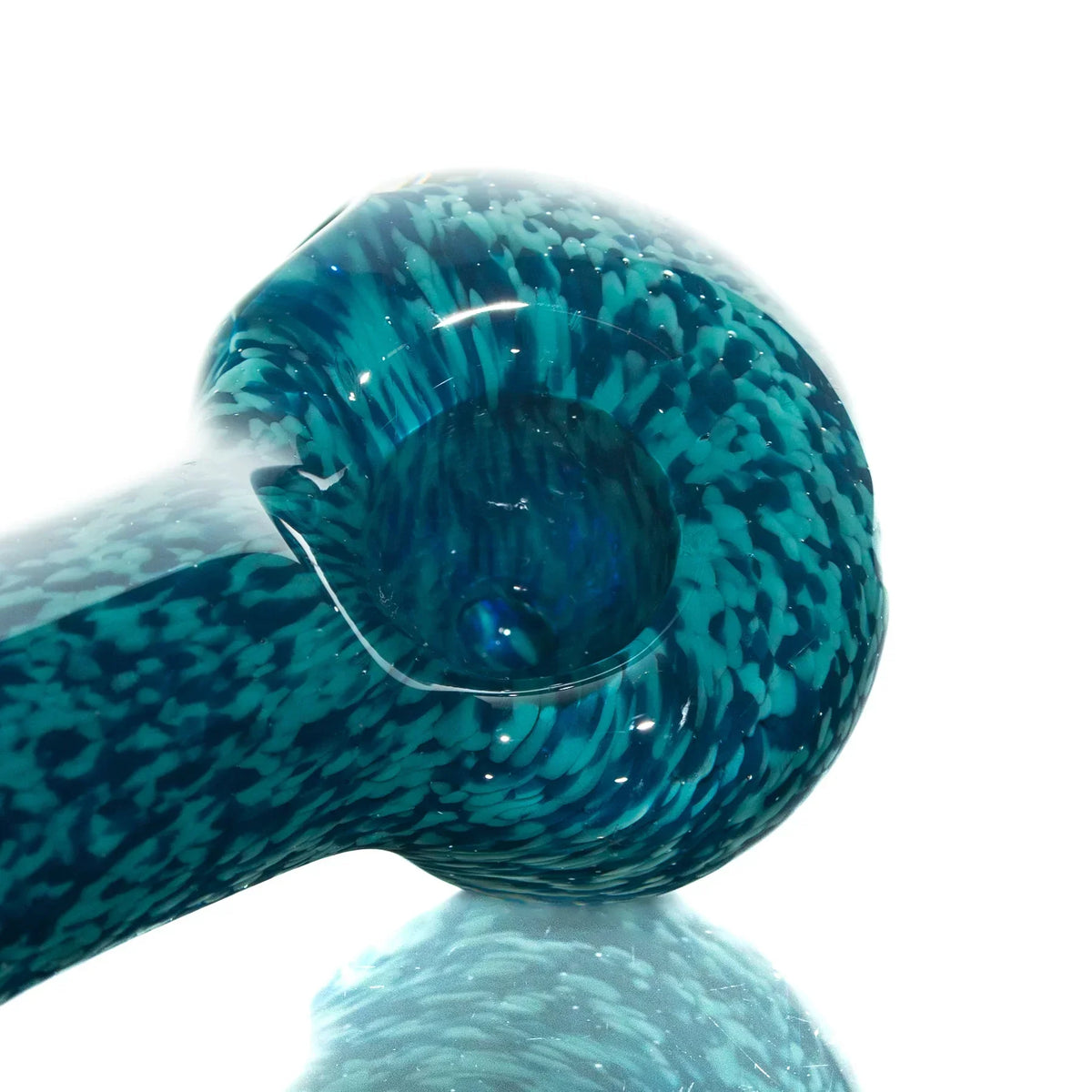 Close-up of blue and teal glass hand pipe with intricate fritted pattern.