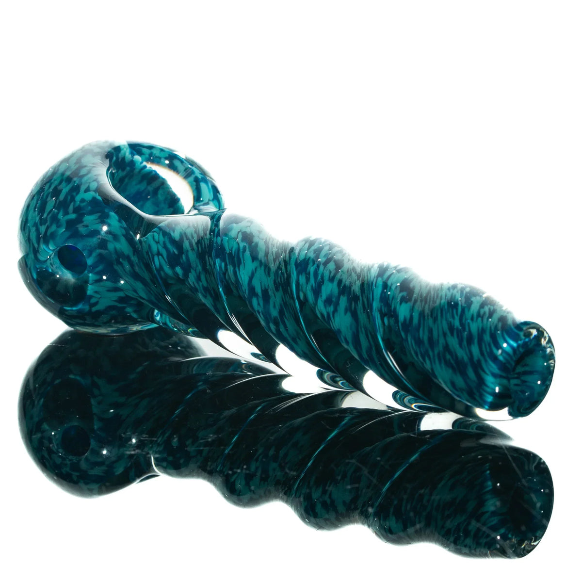 Aqua blue twisted glass hand pipe with speckled design reflected on a white surface
