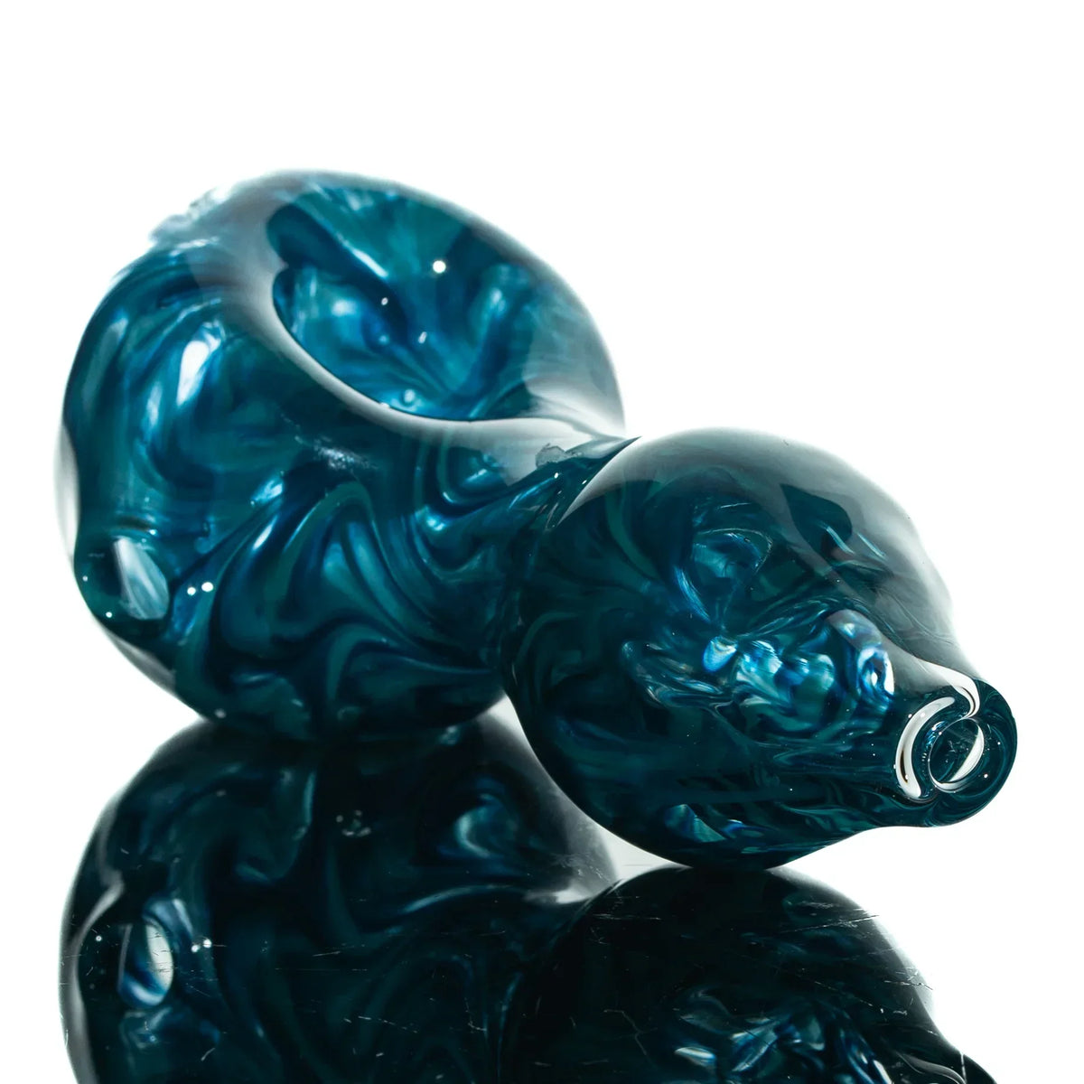 Blue and teal hand-blown glass spoon pipe with hourglass shape on reflective surface