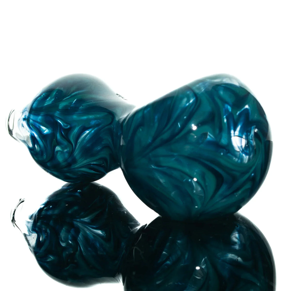 Blue teal glass spoon pipe with hourglass shape and swirl pattern, resting on reflective surface