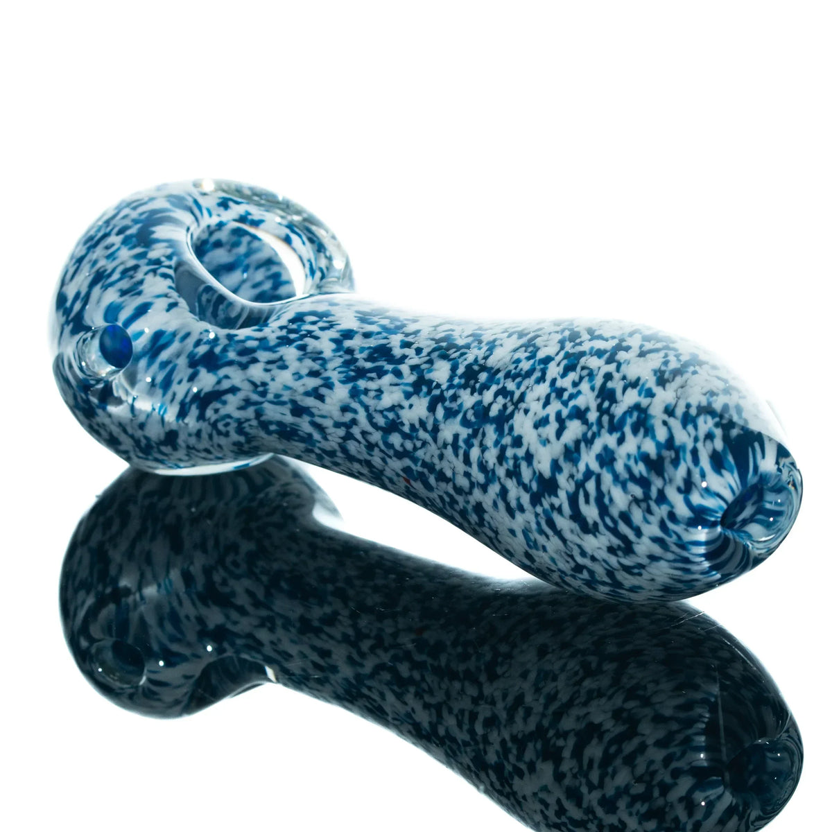 Blue and white frit glass spoon pipe with speckled pattern on a reflective surface