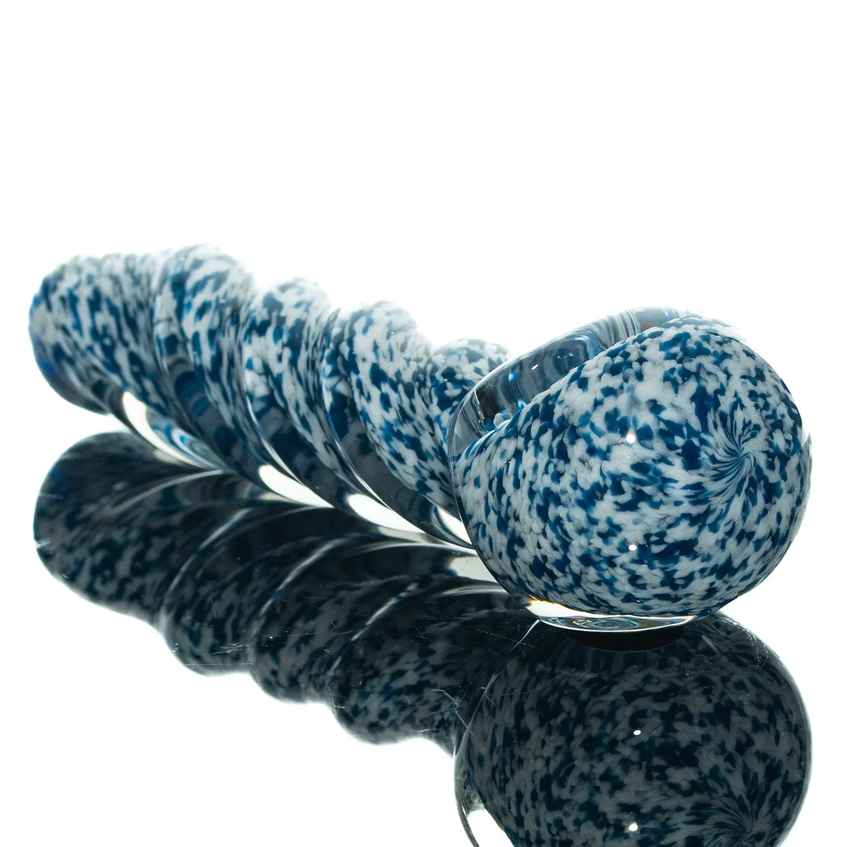 Blue and white frit glass twist spoon pipe with a speckled pattern on a reflective surface