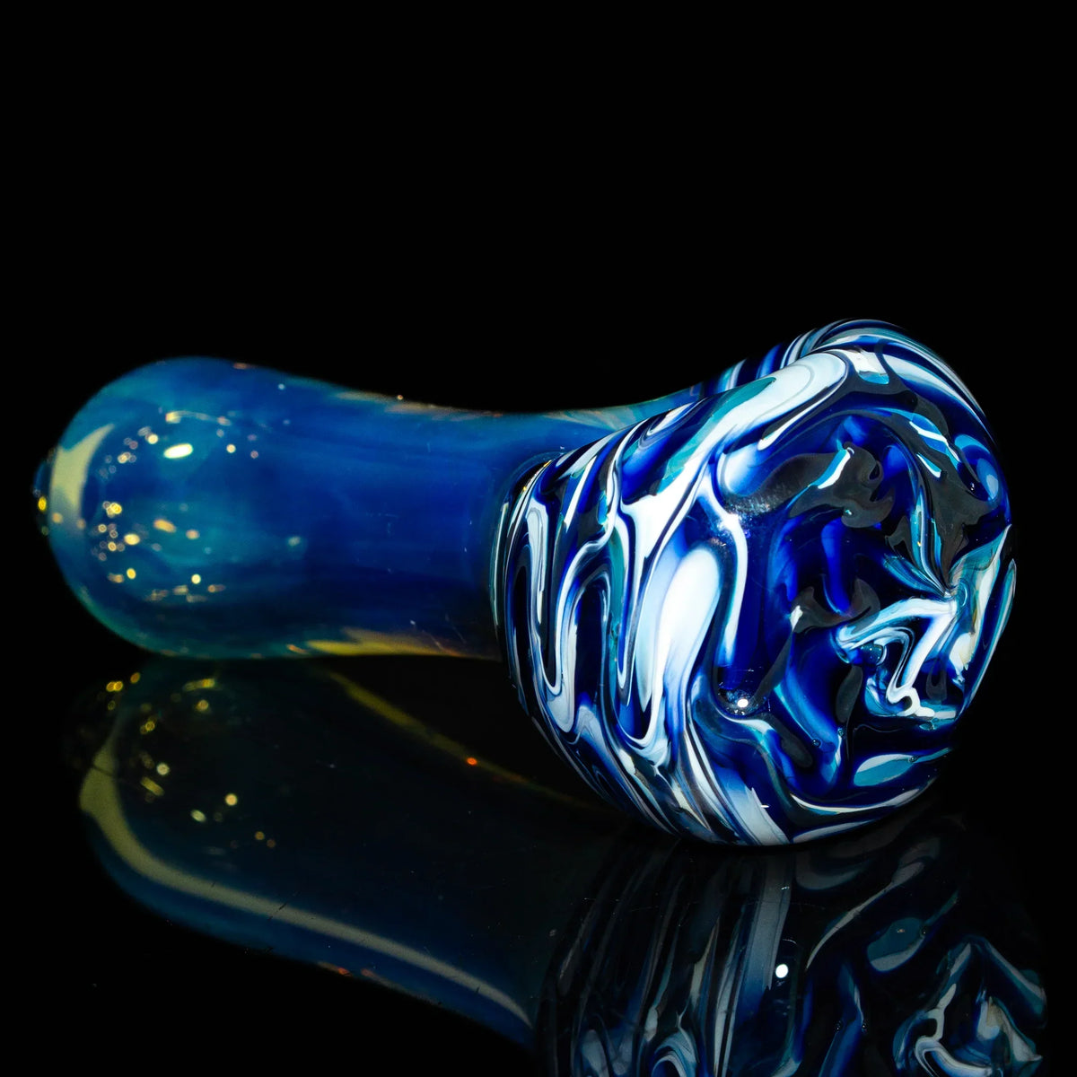 Blue and white fume glass hand pipe with swirled design on black background