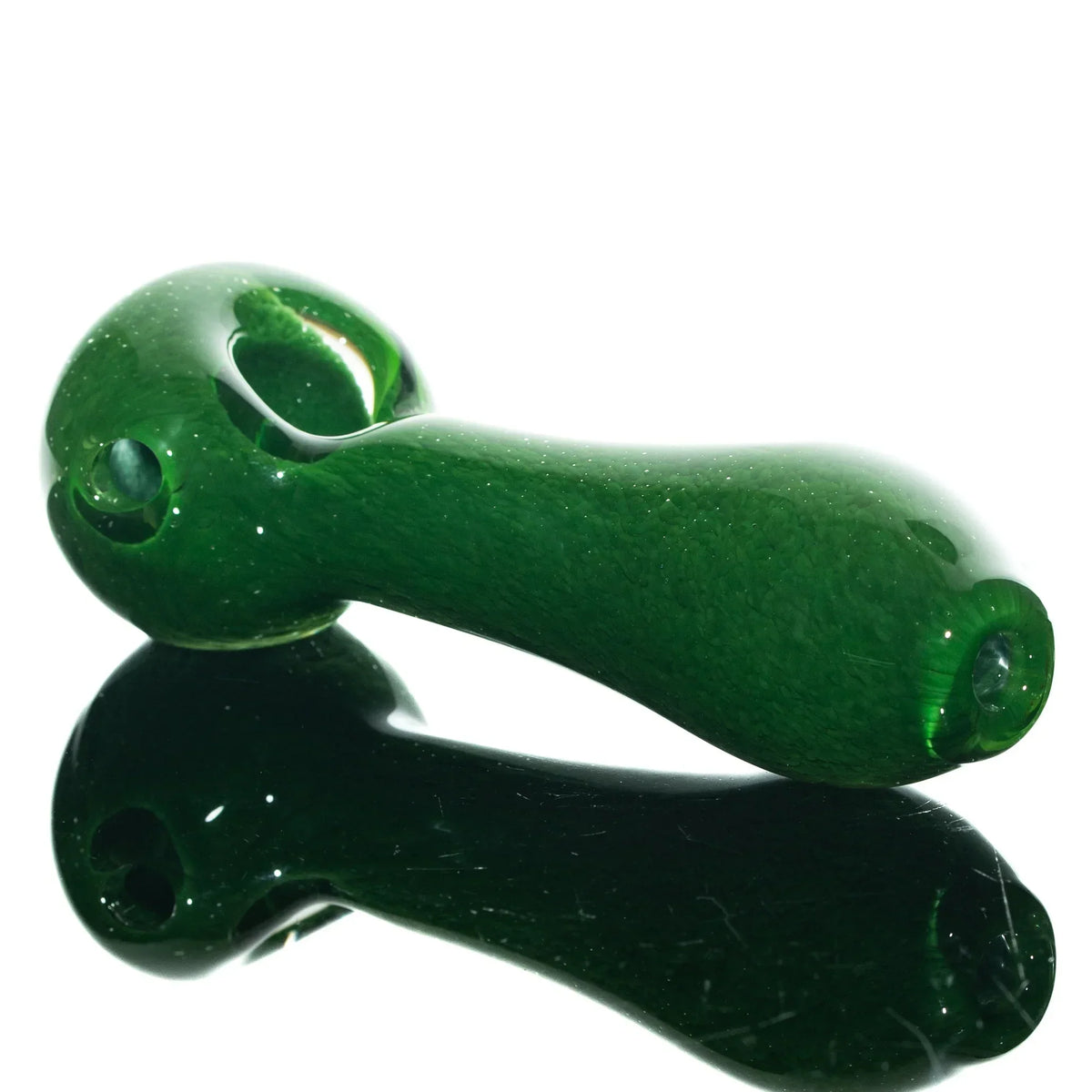 Green glass spoon pipe with a frit finish, shown on a reflective surface