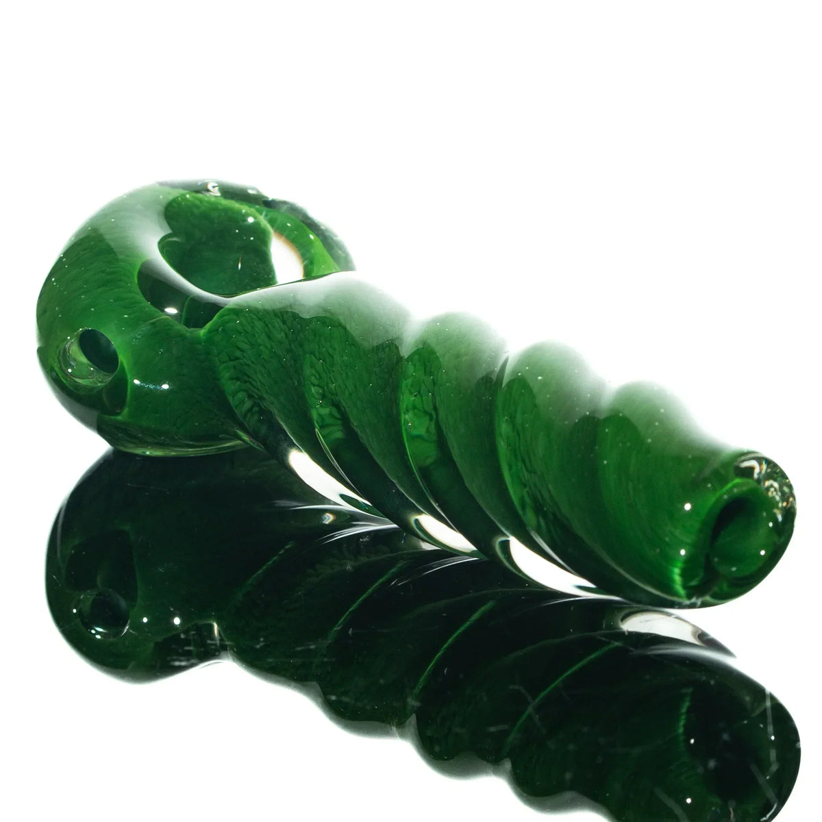 Green glass hand pipe with spiral twist design on a reflective surface