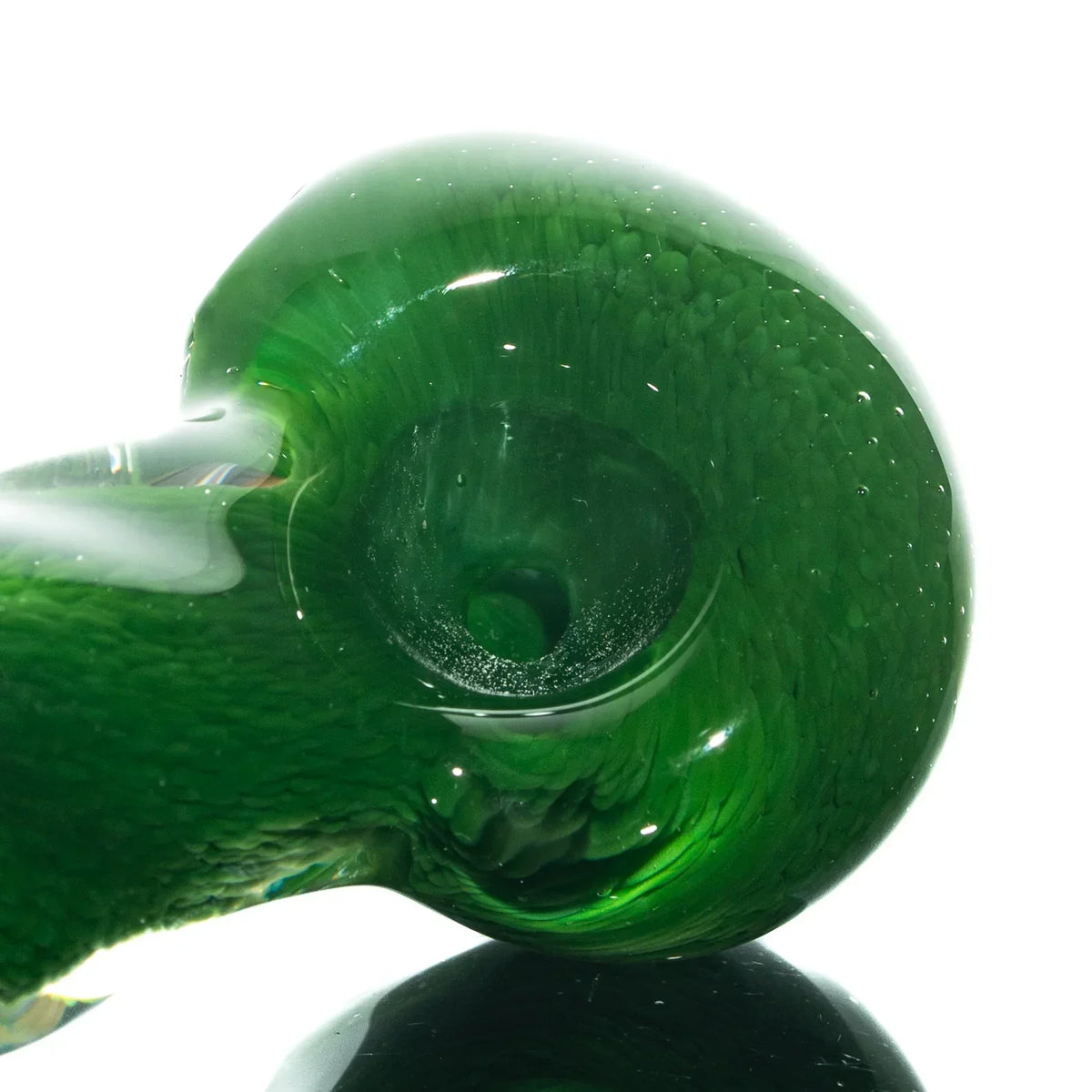 Close-up of a green glass spoon pipe with fritted texture and a deep bowl