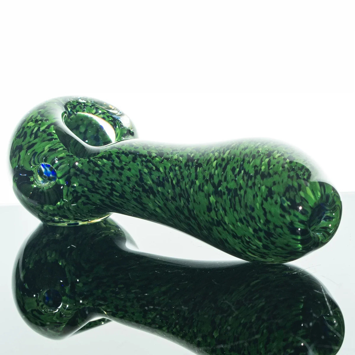 Green and black frit glass spoon hand pipe with speckled design on reflective surface
