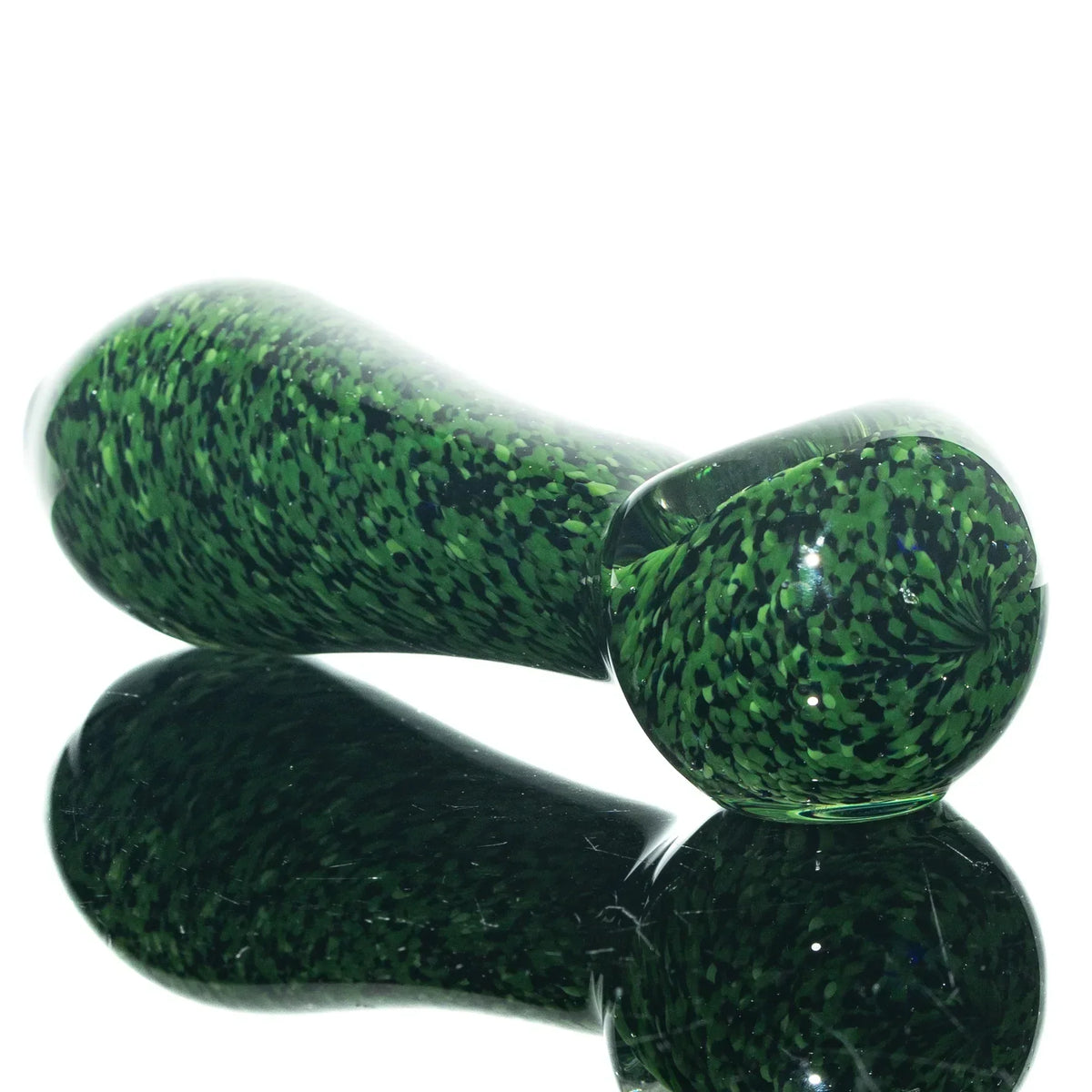 Green and black frit glass spoon pipe with speckled pattern on reflective surface