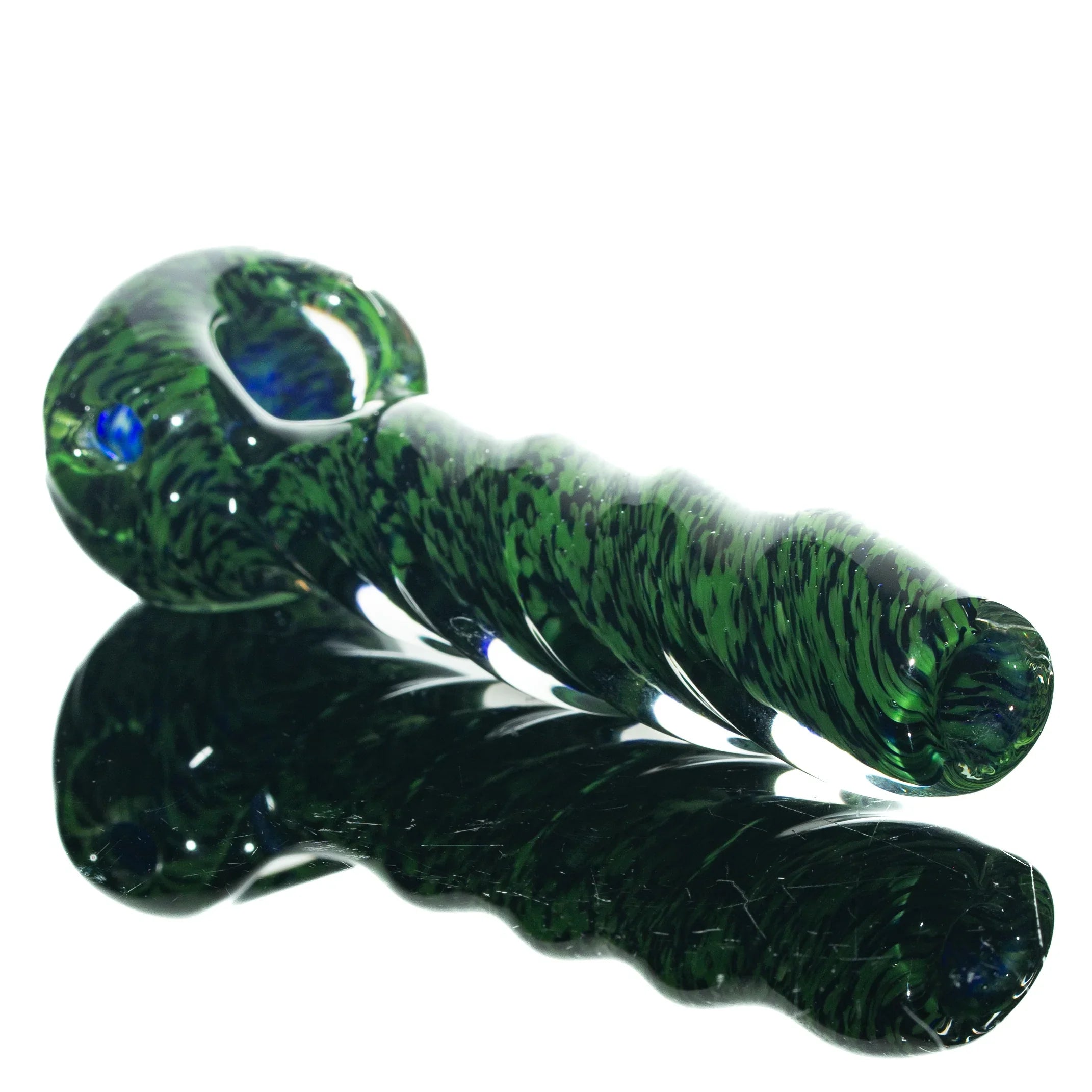 Green and black glass twist hand pipe with frit design on a reflective surface
