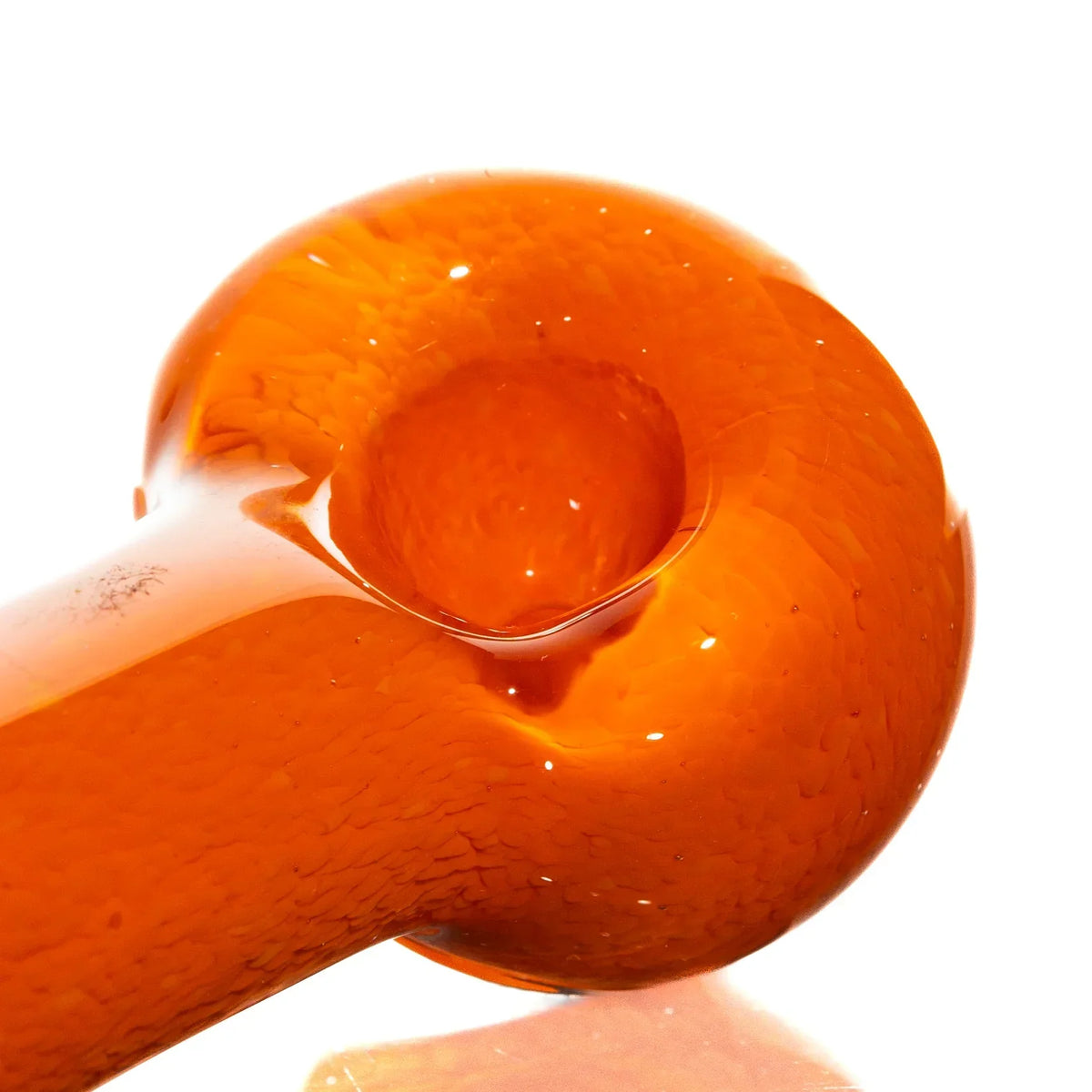 Close-up of an orange frit glass hand pipe with a smooth, rounded bowl design
