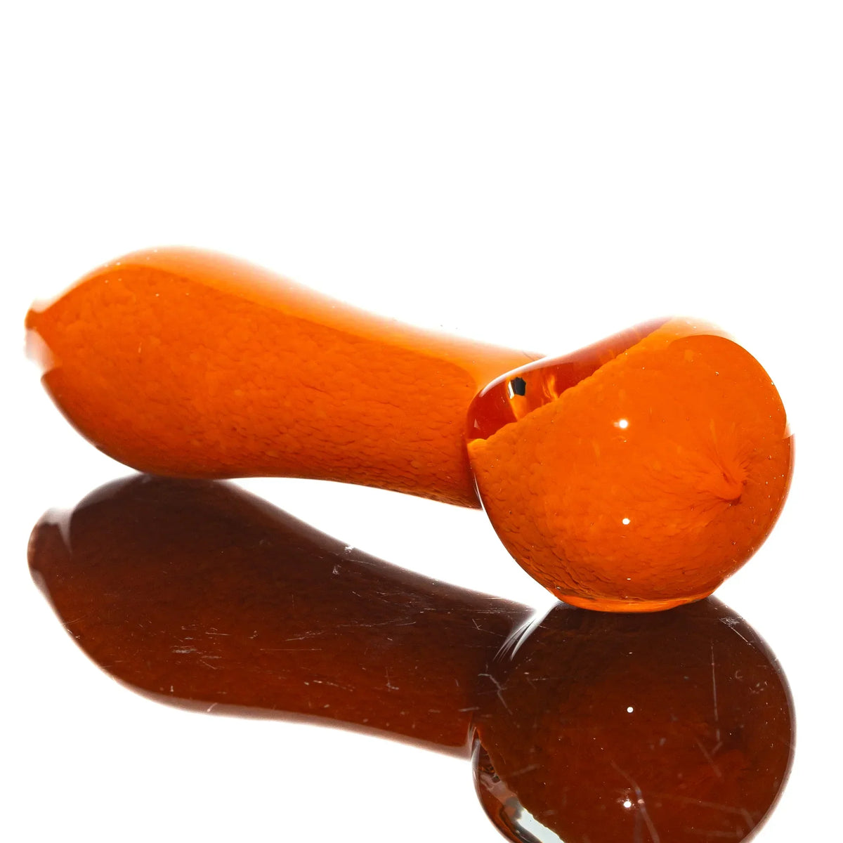 Orange frit glass hand pipe with reflective base on white background