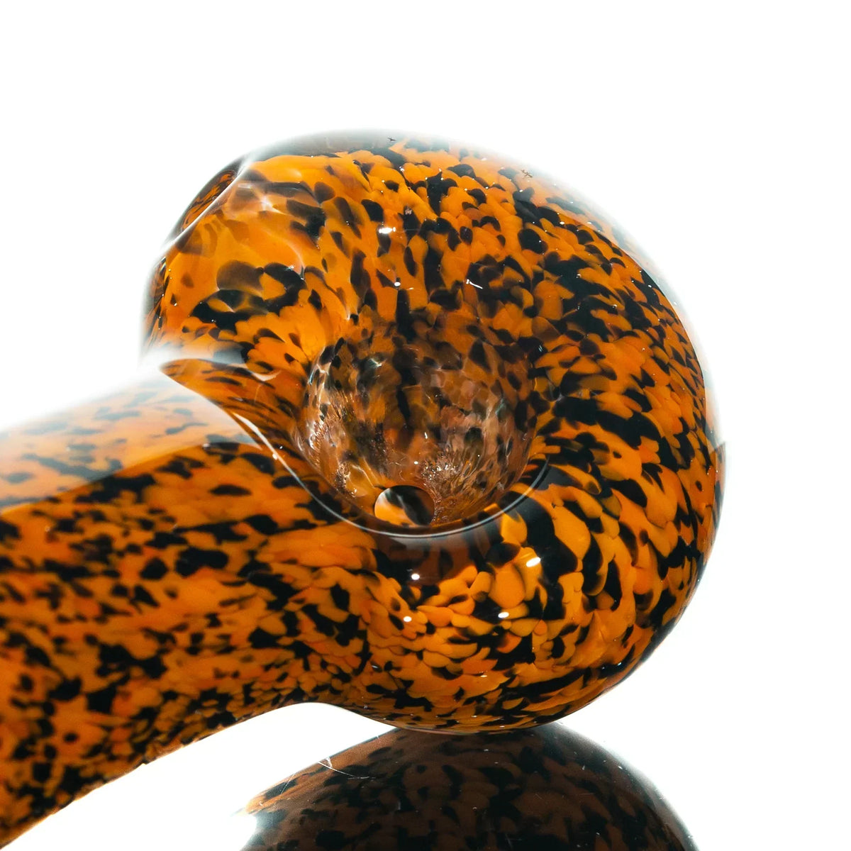 Orange and black frit glass hand pipe with speckled design on a white background