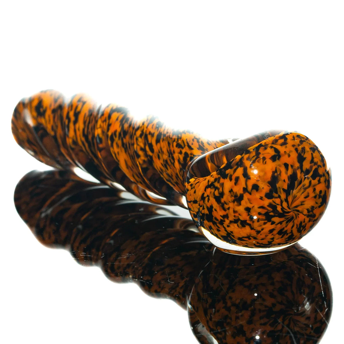 Orange and black frit glass twist spoon pipe on reflective surface