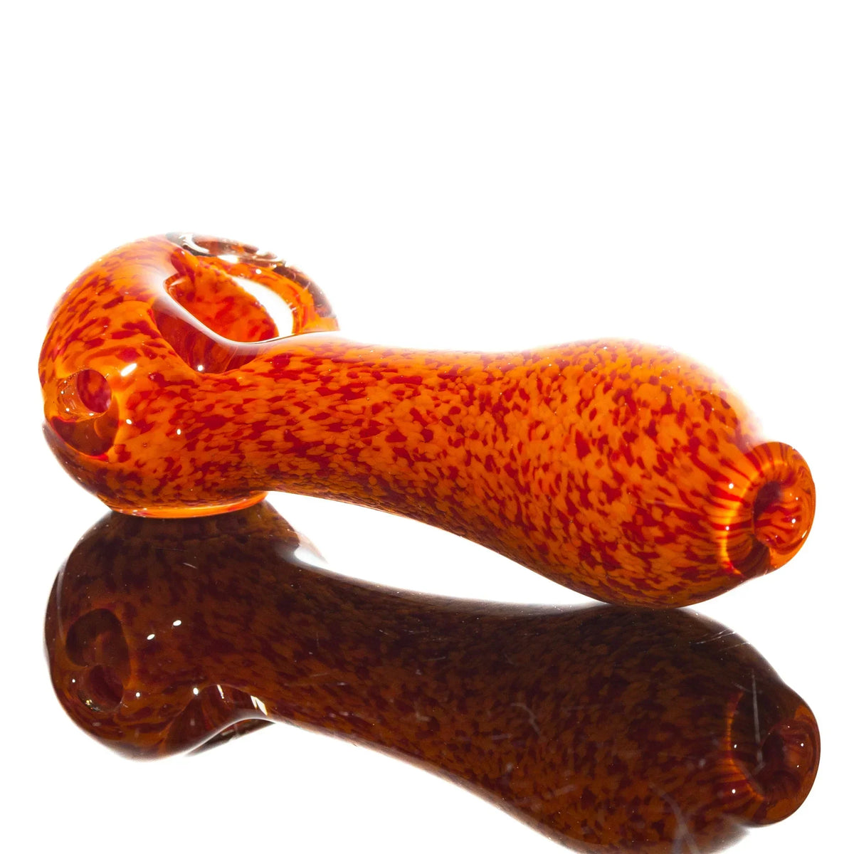 Orange and red frit glass spoon pipe with speckled pattern on white background