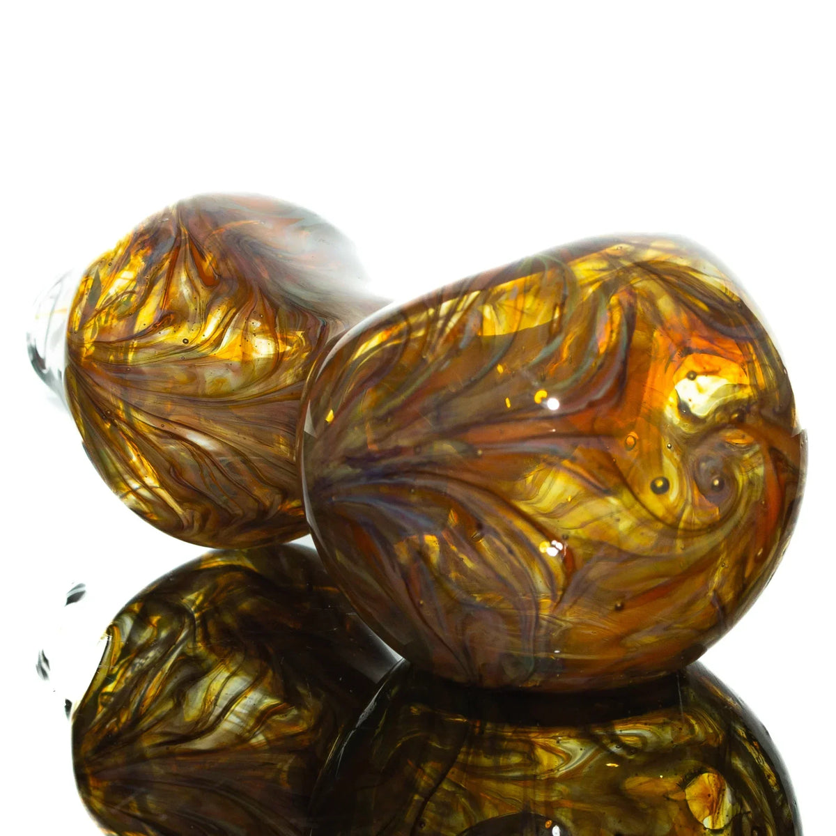 Handcrafted hourglass glass pipe with orange and amber swirled design on reflective surface