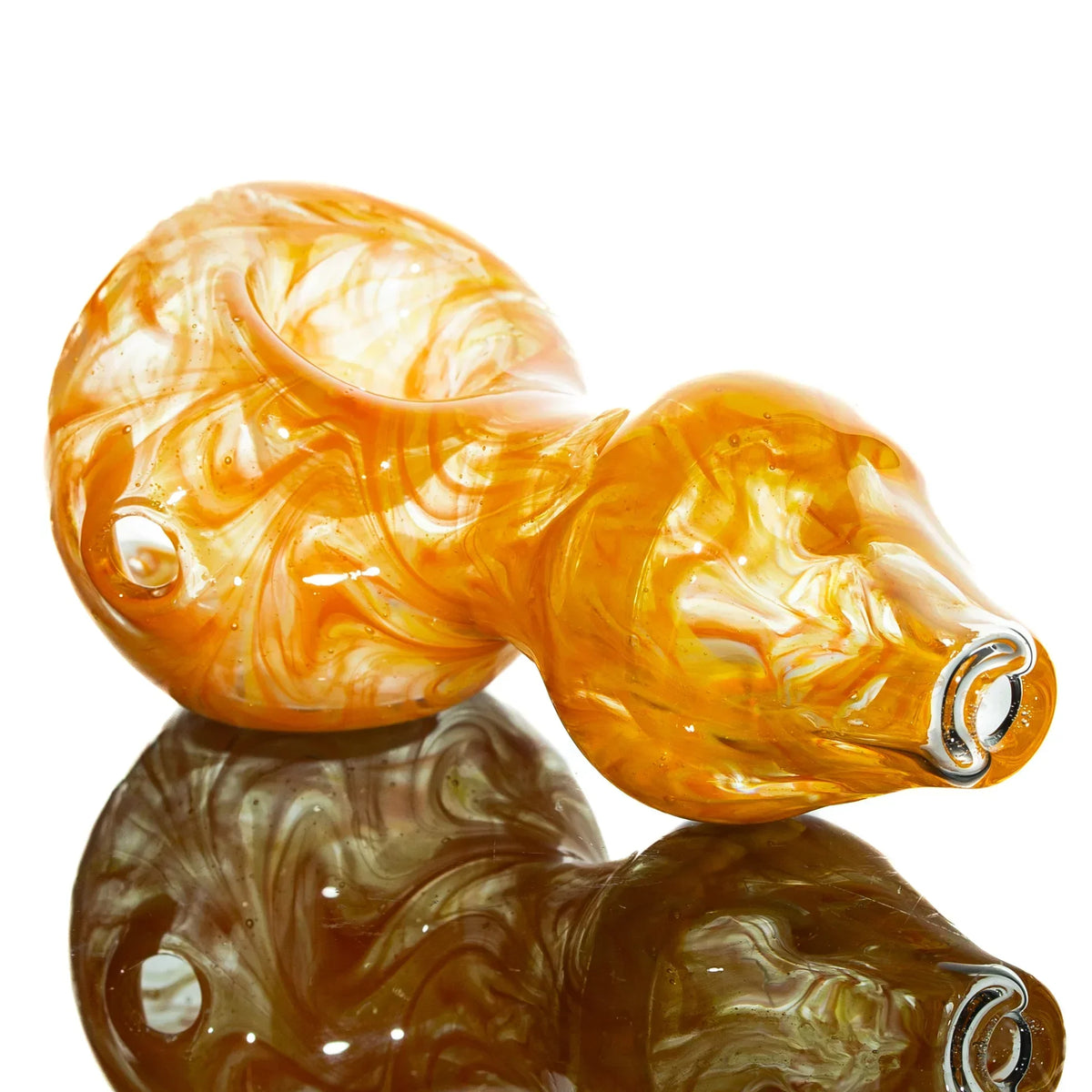 Hand-blown orange and yellow glass spoon pipe with swirled pattern on reflective surface