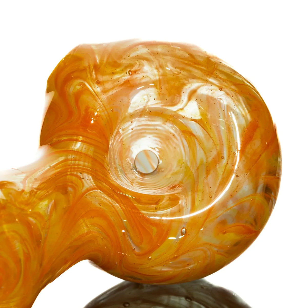 Close-up of orange and yellow swirled glass pipe with carb hole for smoking.
