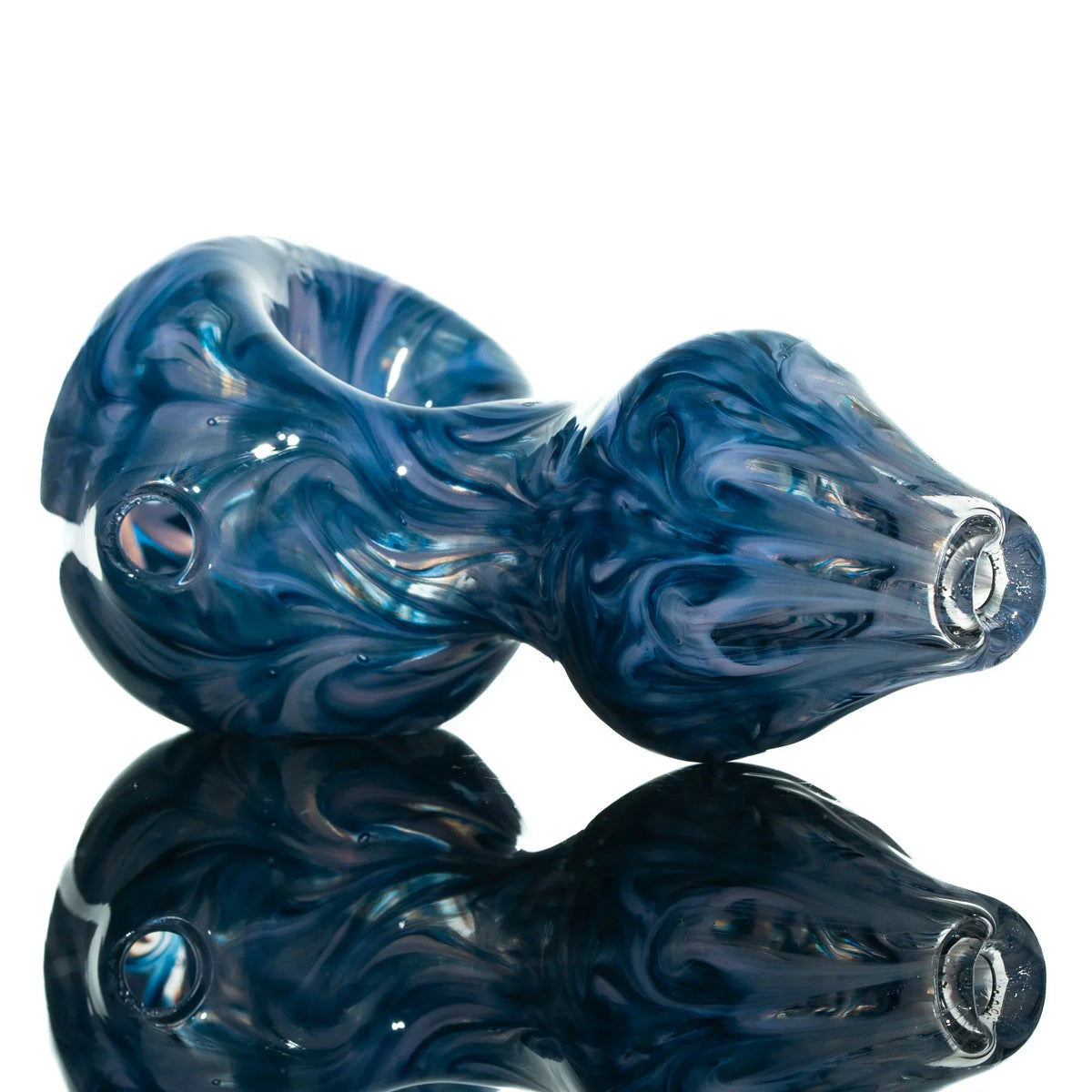 Hand-blown blue glass spoon pipe with swirled design on reflective white background