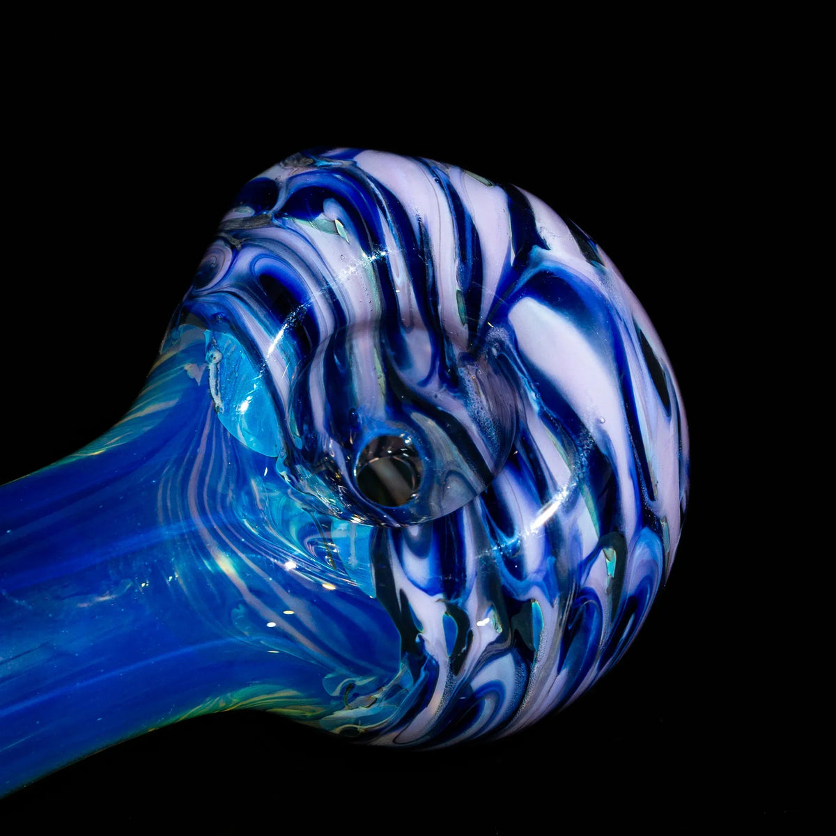 Blue and white swirled glass hand pipe close-up on black background, artistic smoking accessory