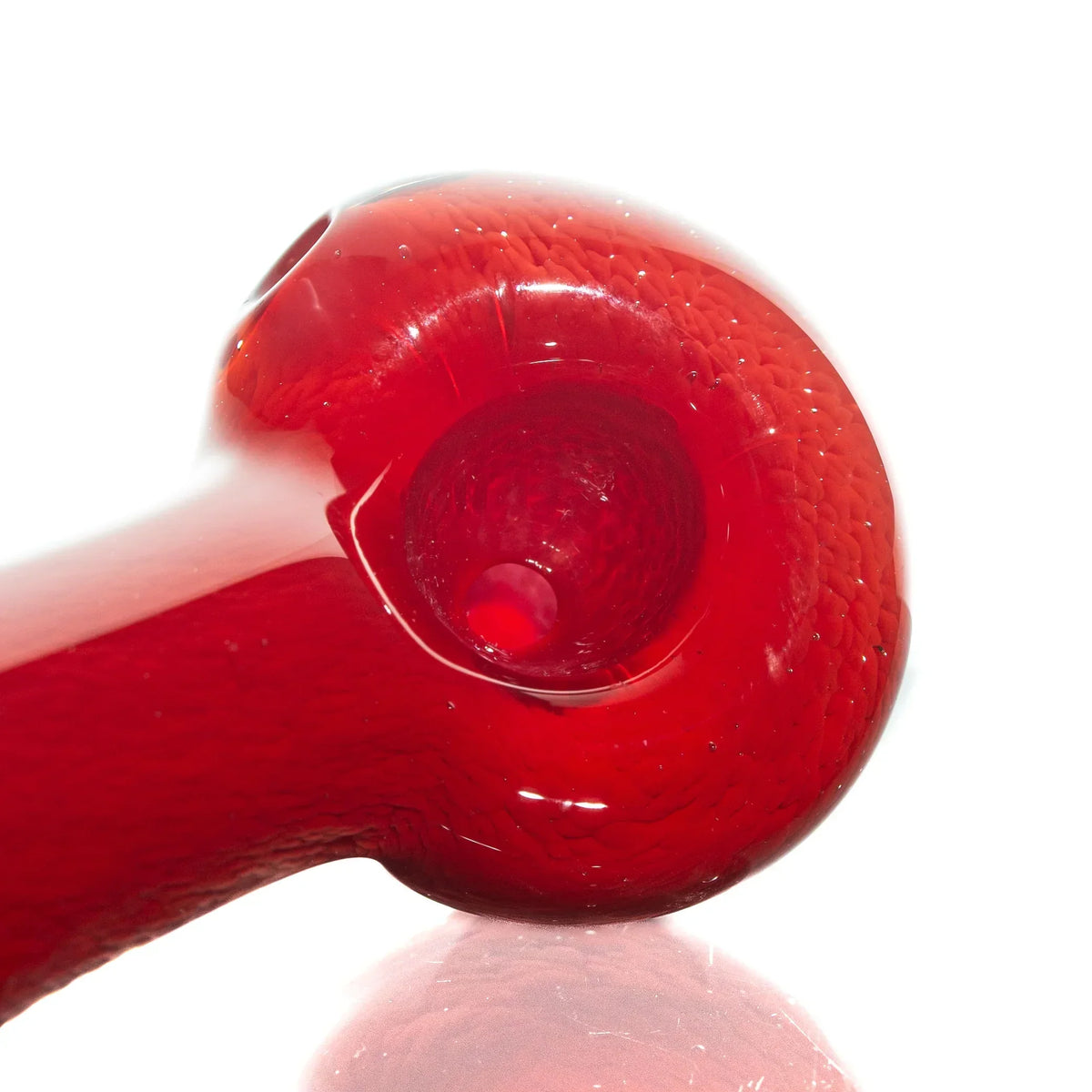 Red glass hand pipe with frit design, closeup on bowl, clean white background