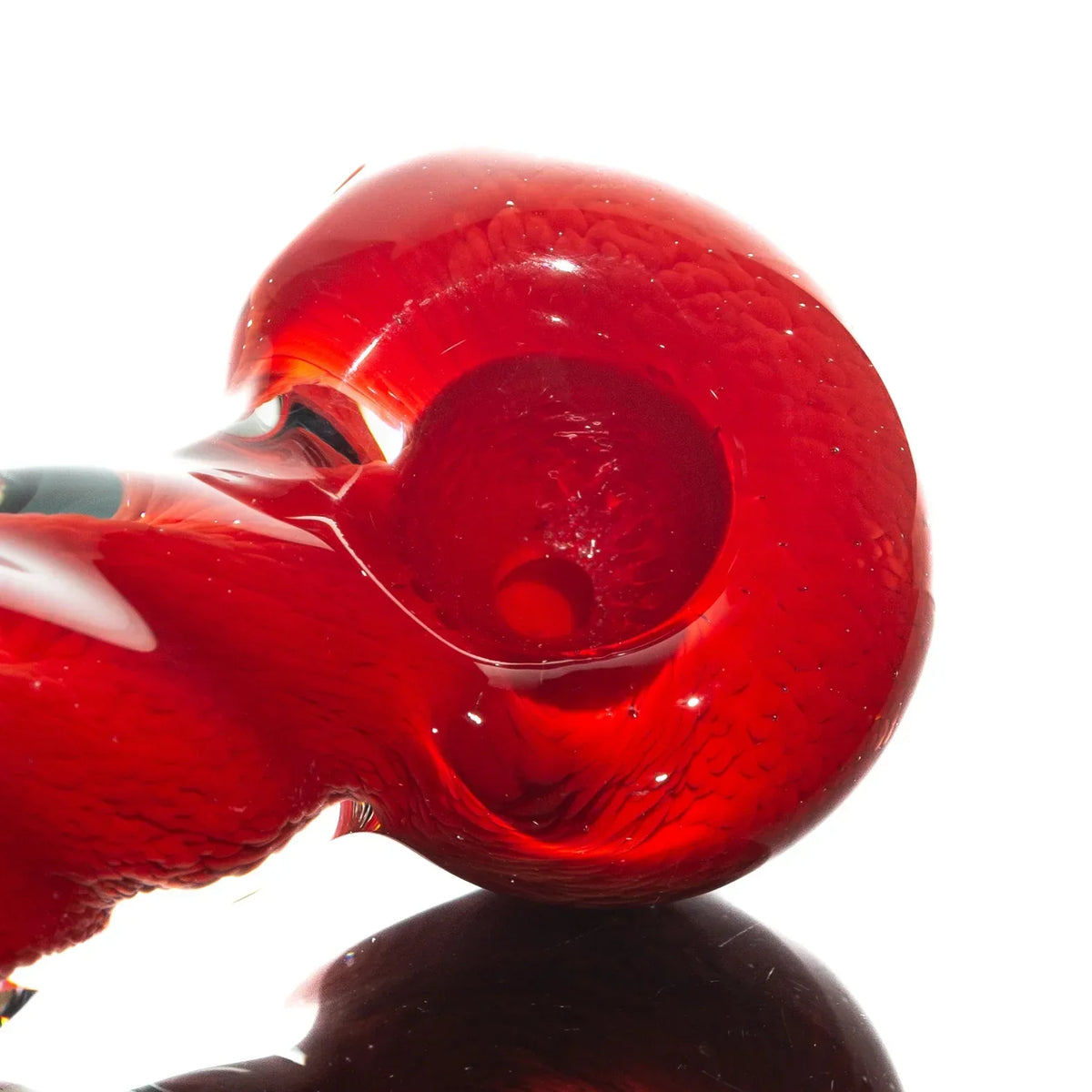 Close-up of a red glass hand pipe with twisted frit design, smoking accessory