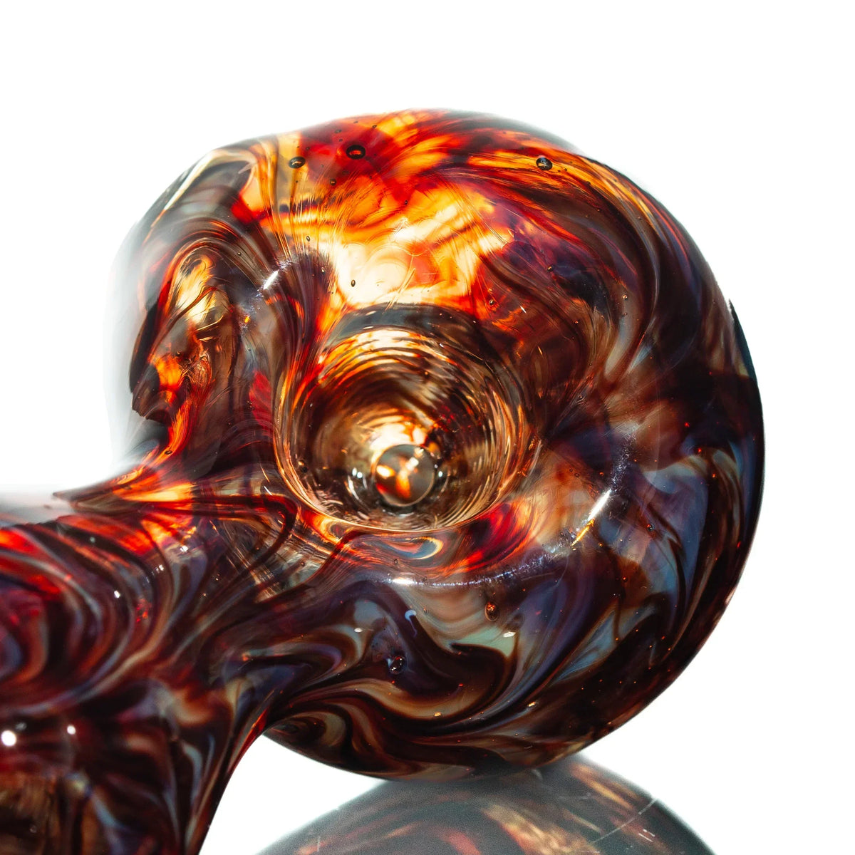 Close-up of a red slyme wrap hourglass glass spoon pipe with swirling patterns