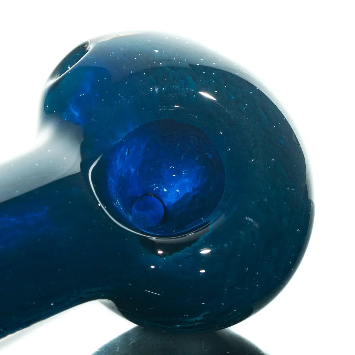 Close-up of a blue glass hand pipe with swirled frit details, shown on a white background.