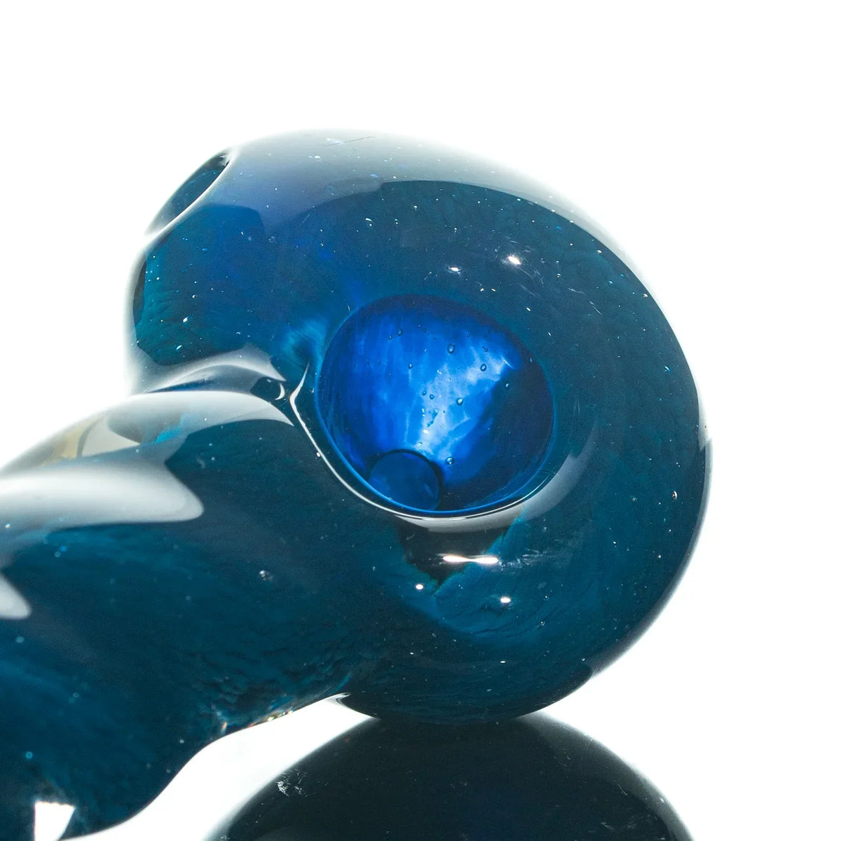 Close-up of a blue glass hand pipe with a deep bowl and reflective surface on white background.