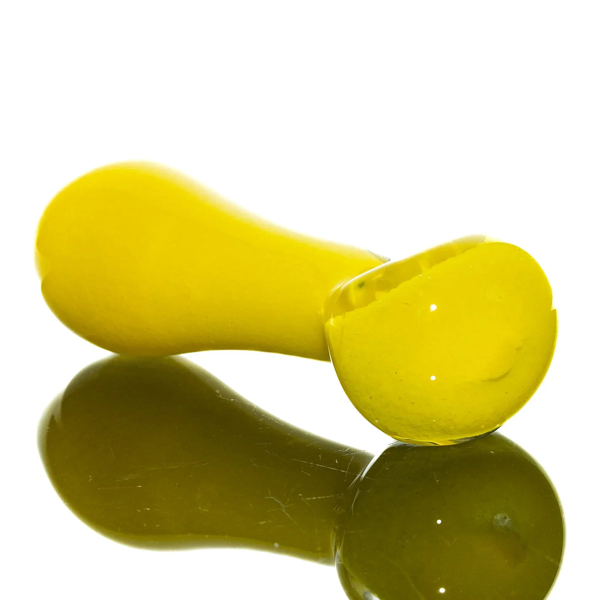 Yellow glass spoon pipe with smooth finish on reflective surface