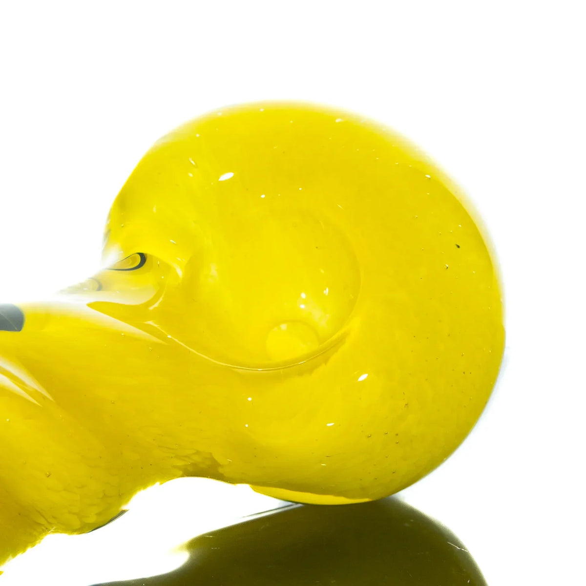 Close-up of yellow glass hand pipe bowl with reflective surface